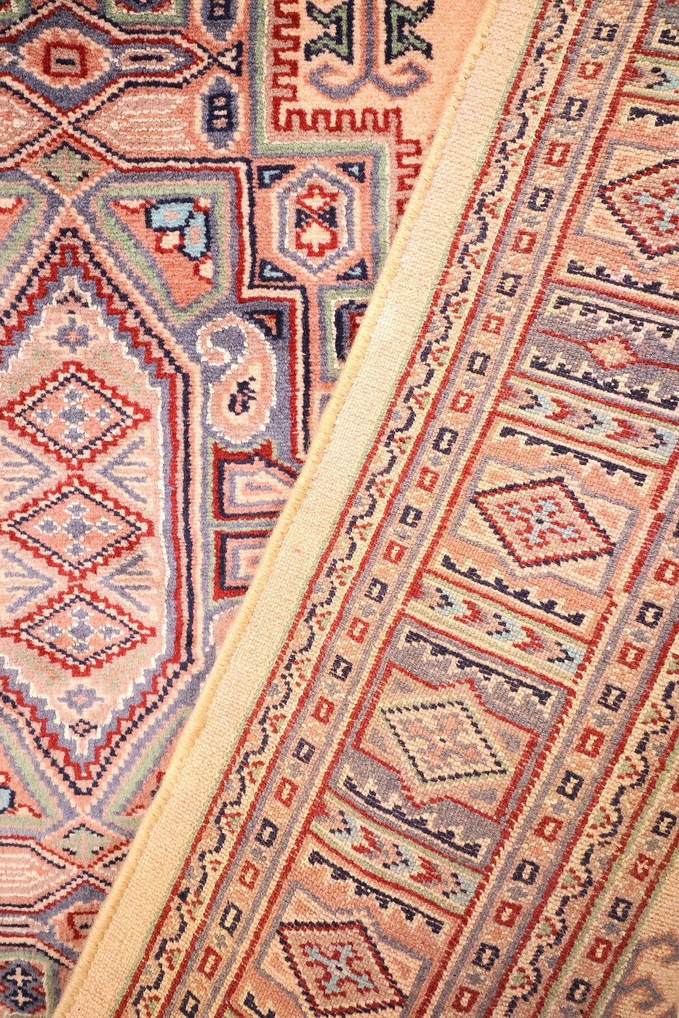 Coin replié du tapis Caucase, écoinçons en escalier et boteh stylisés