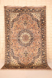 Tapis Agra rose 175 × 123 cm, vue d'ensemble avec médaillon ivoire et bordure bleu nuit
