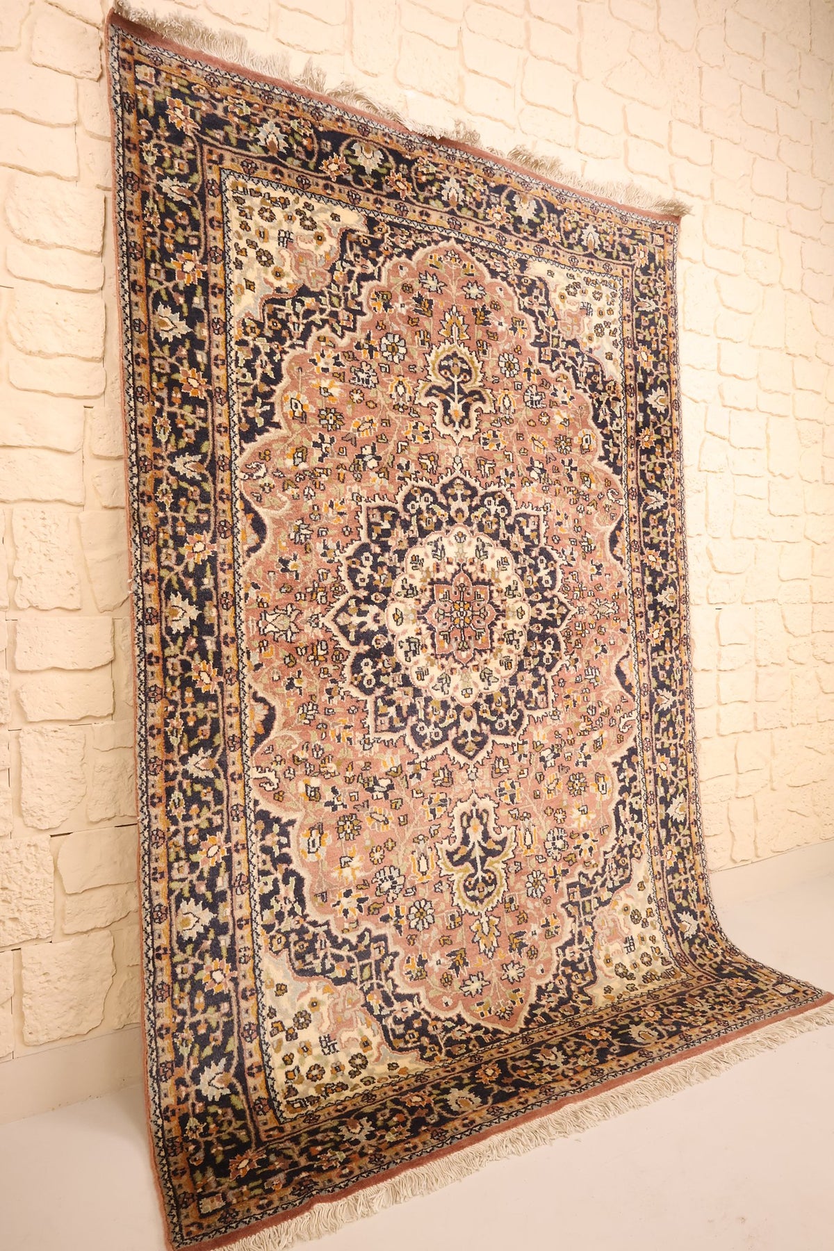 Tapis Agra rose et bleu vu de biais, franges blanches aux extrémités