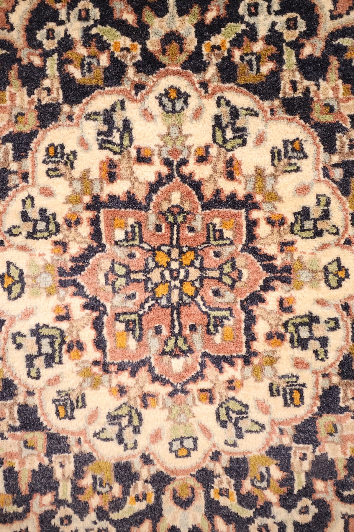 Détail du médaillon central ivoire et rose du tapis Agra, rinceaux fleuris