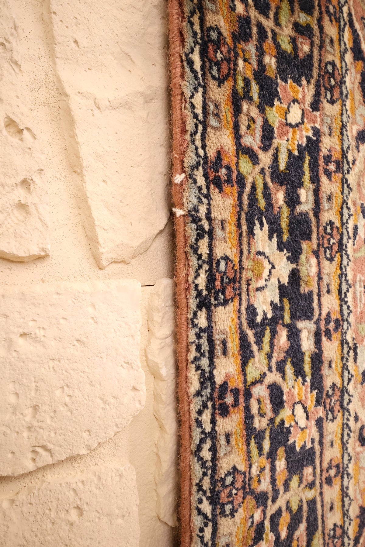 Lisière du tapis Agra rose et bleu, bord net le long du mur