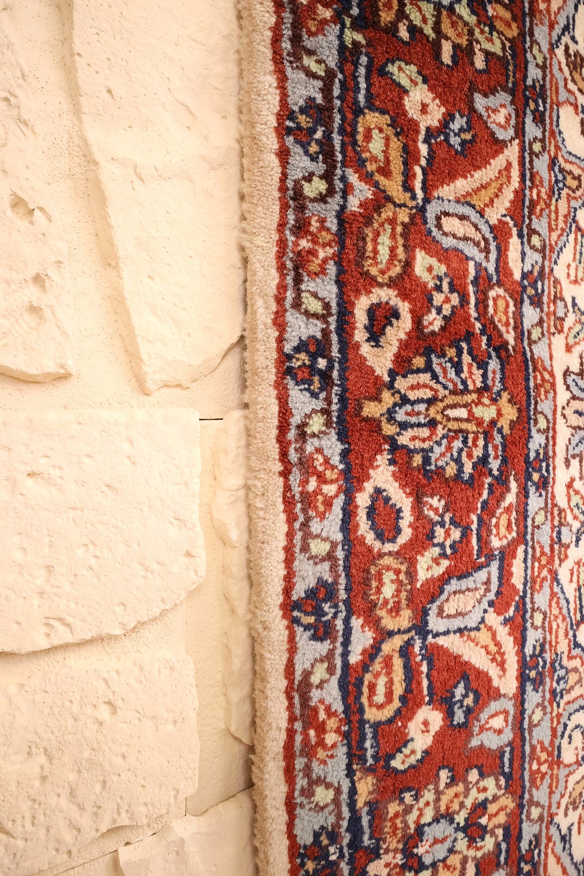 Lisière du tapis Agra, rinceaux fleuris rouge brique et bleu marine