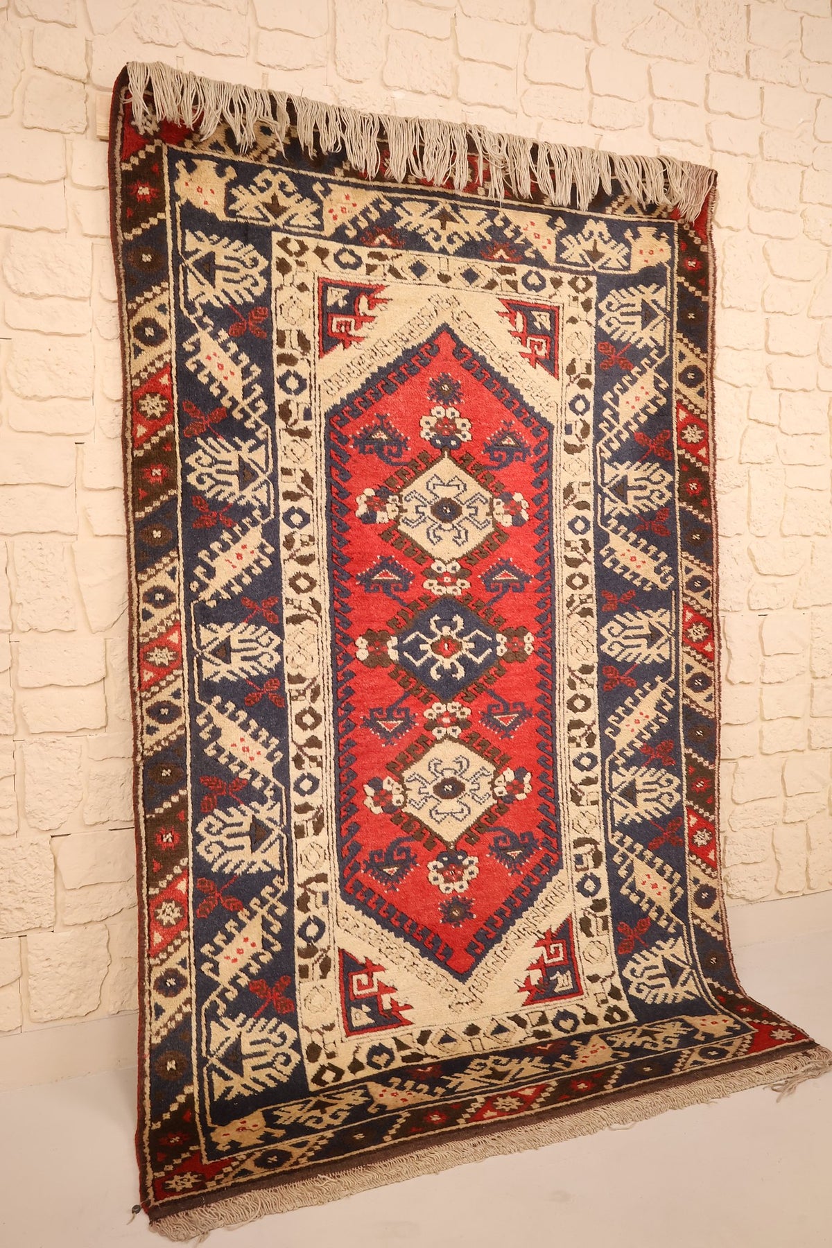Tapis Anadol rectangulaire rouge et bleu, vue de biais montrant la colonne de médaillons