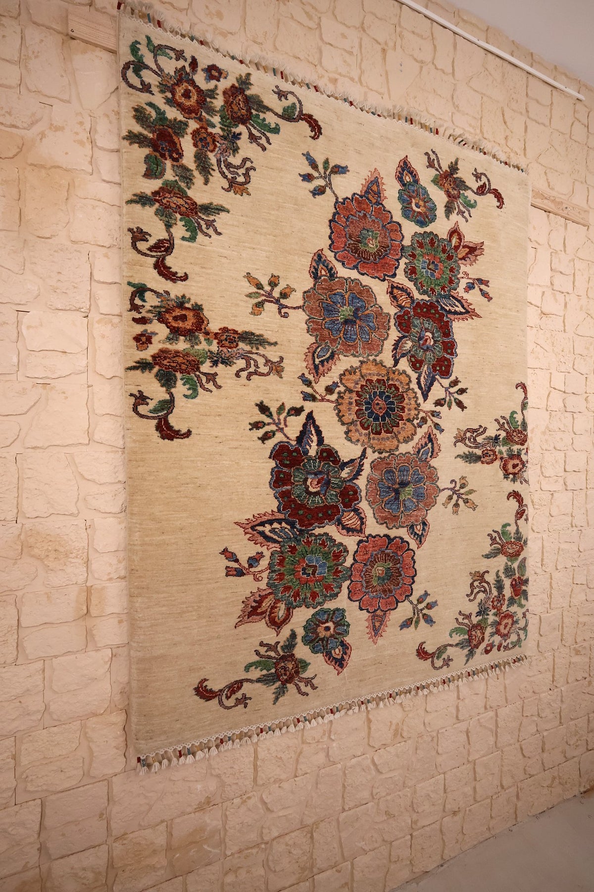 Tapis Aryana beige en laine vu de biais, fleurs disposées en diagonale
