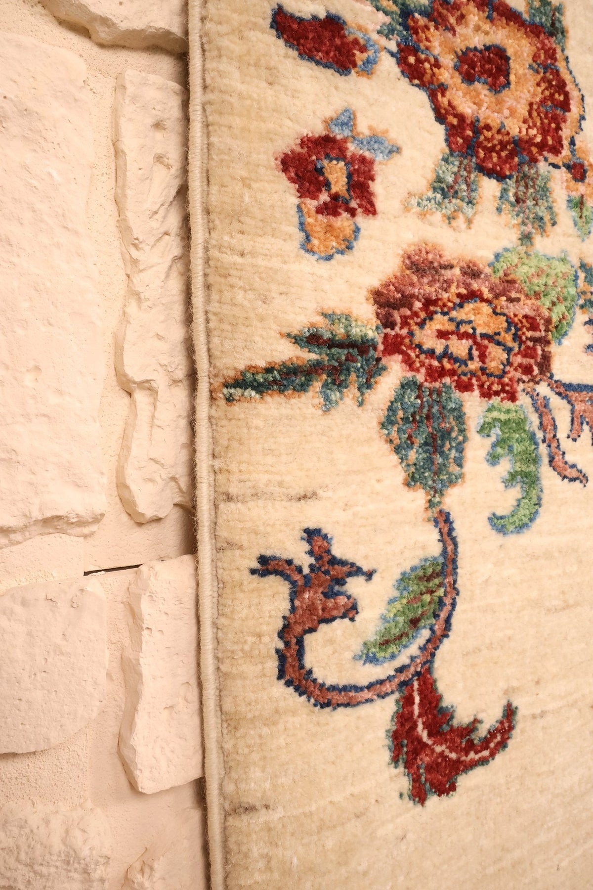 Lisière du tapis Aryana beige, fleurs rouges et vertes en bord de champ
