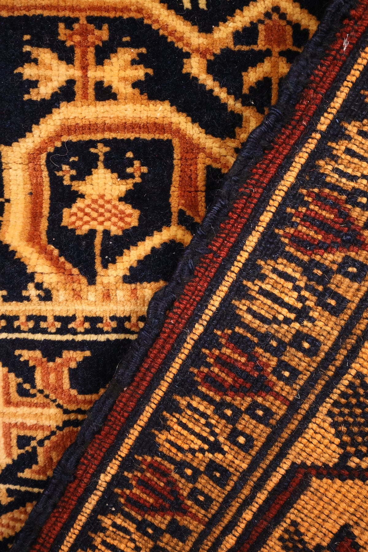 Coin replié du tapis Baloutch, laine nouée à la main et envers visible