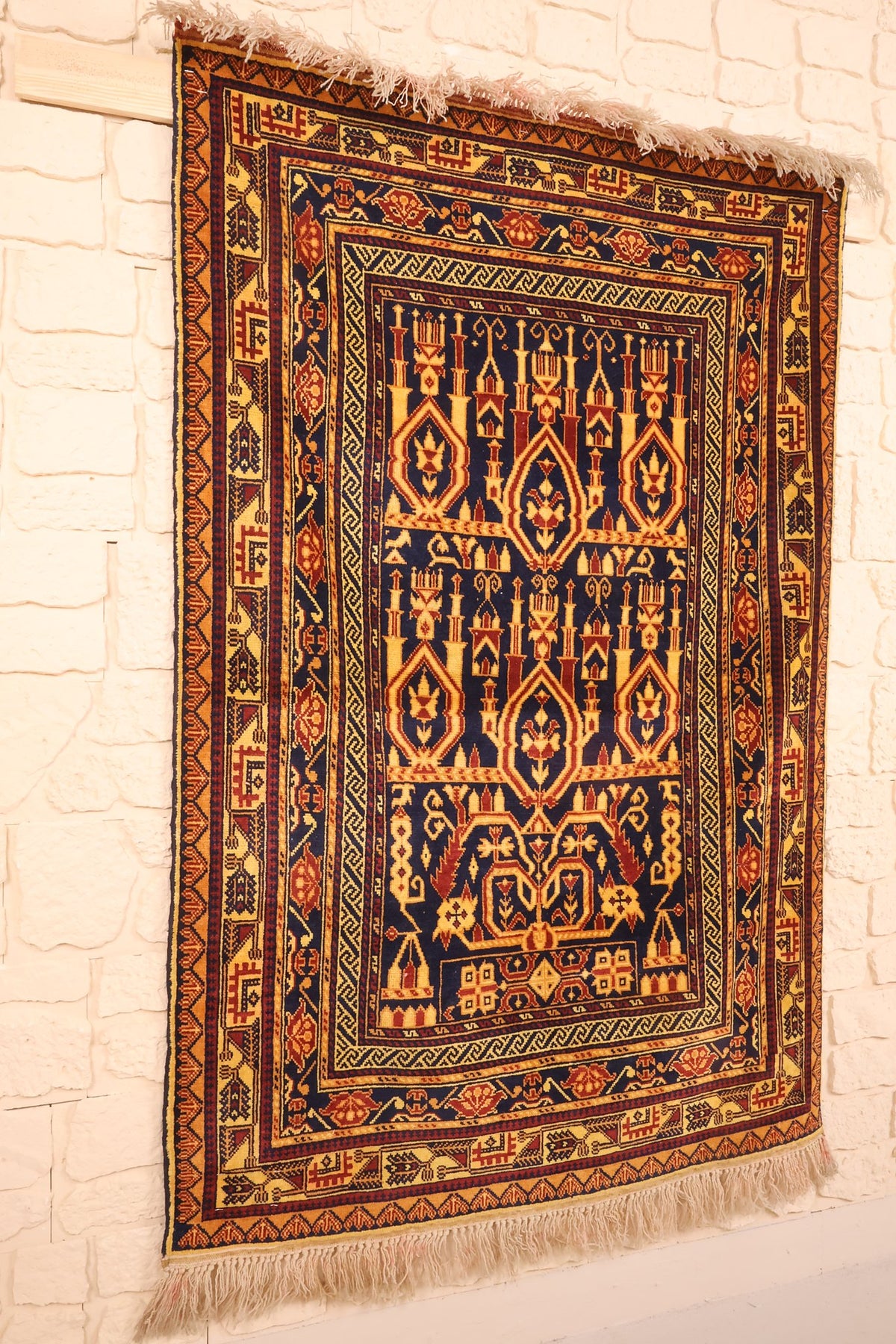 Tapis Baloutch en laine noué main, vue de biais montrant arcs et niches jaune or