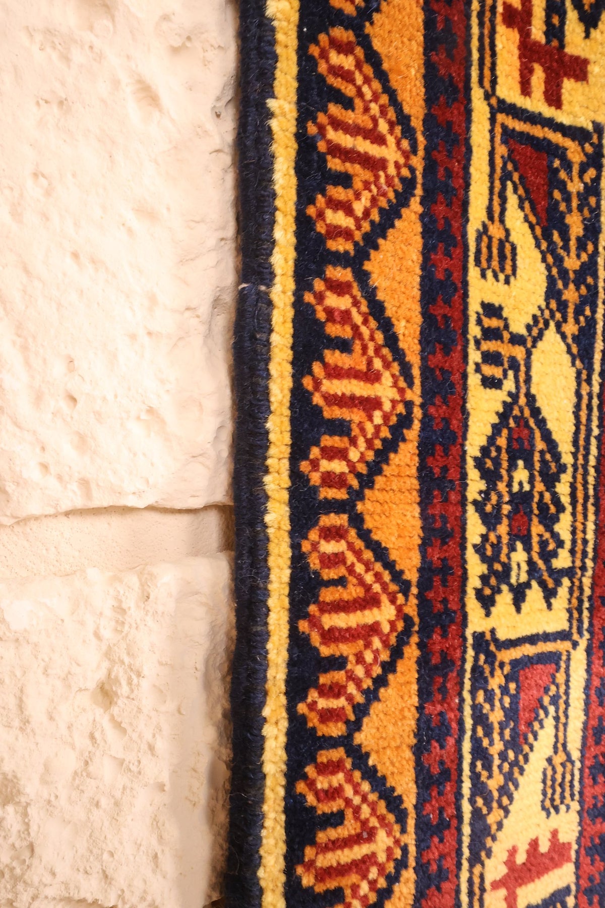 Lisière du tapis Baloutch bleu, galon latéral et frise orange à chevrons