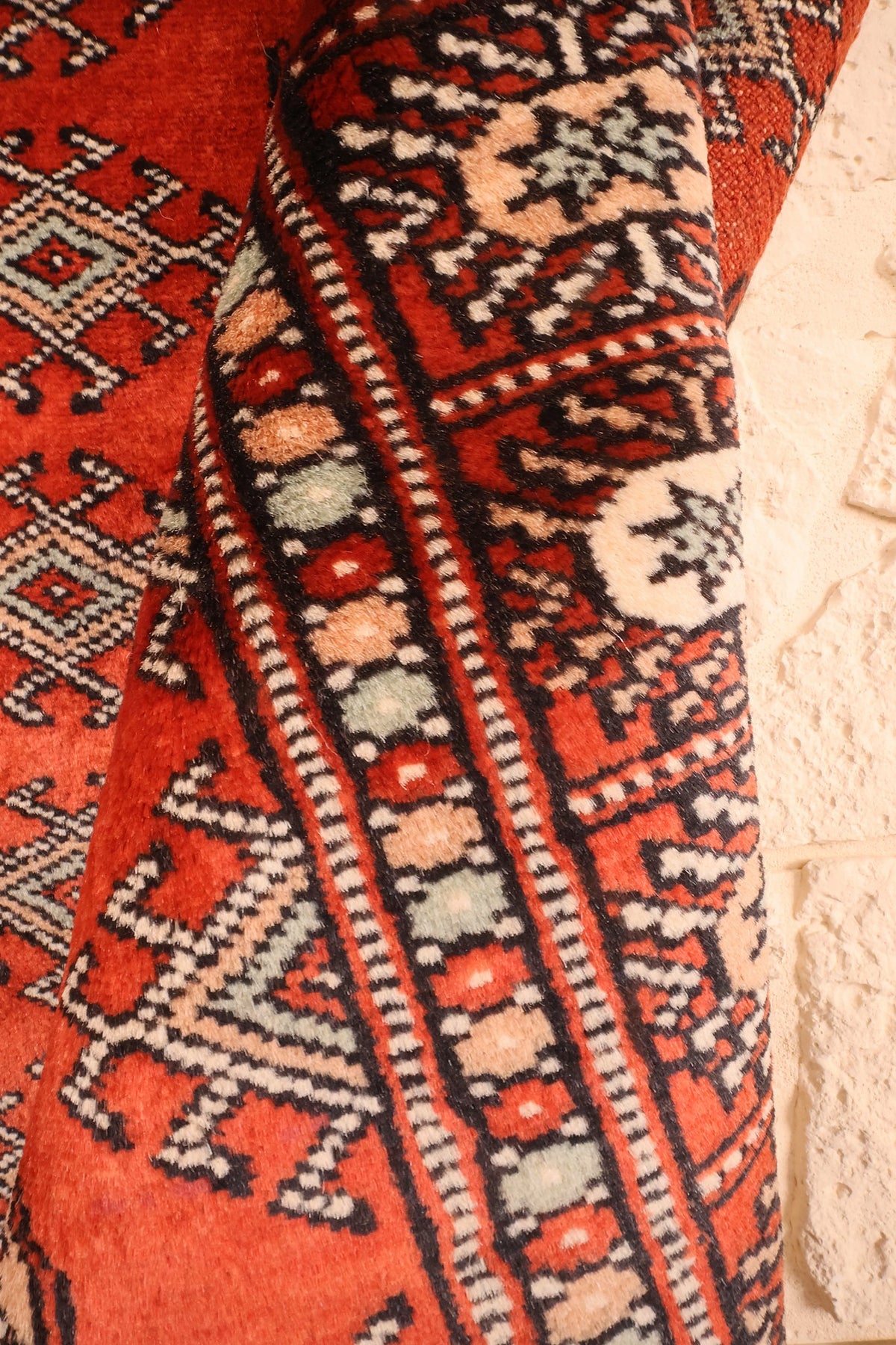 Coin replié du tapis Boukhara 149 × 90 cm, épaisseur de la laine visible