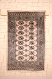 Tapis Boukhara en laine noué main, champ beige rosé à deux rangées de guls
