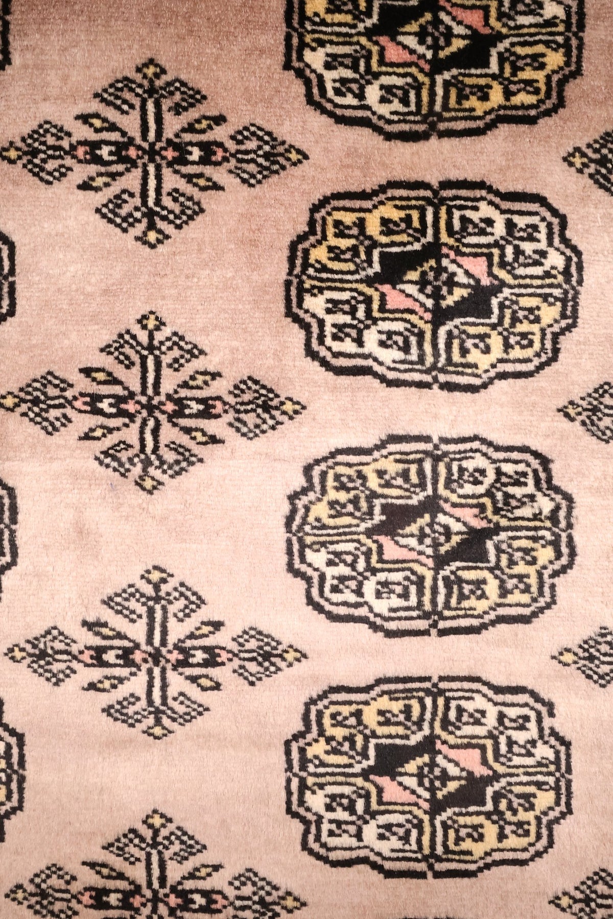 Détail des guls octogonaux noirs et jaunes et des croix dentelées, fond beige rosé
