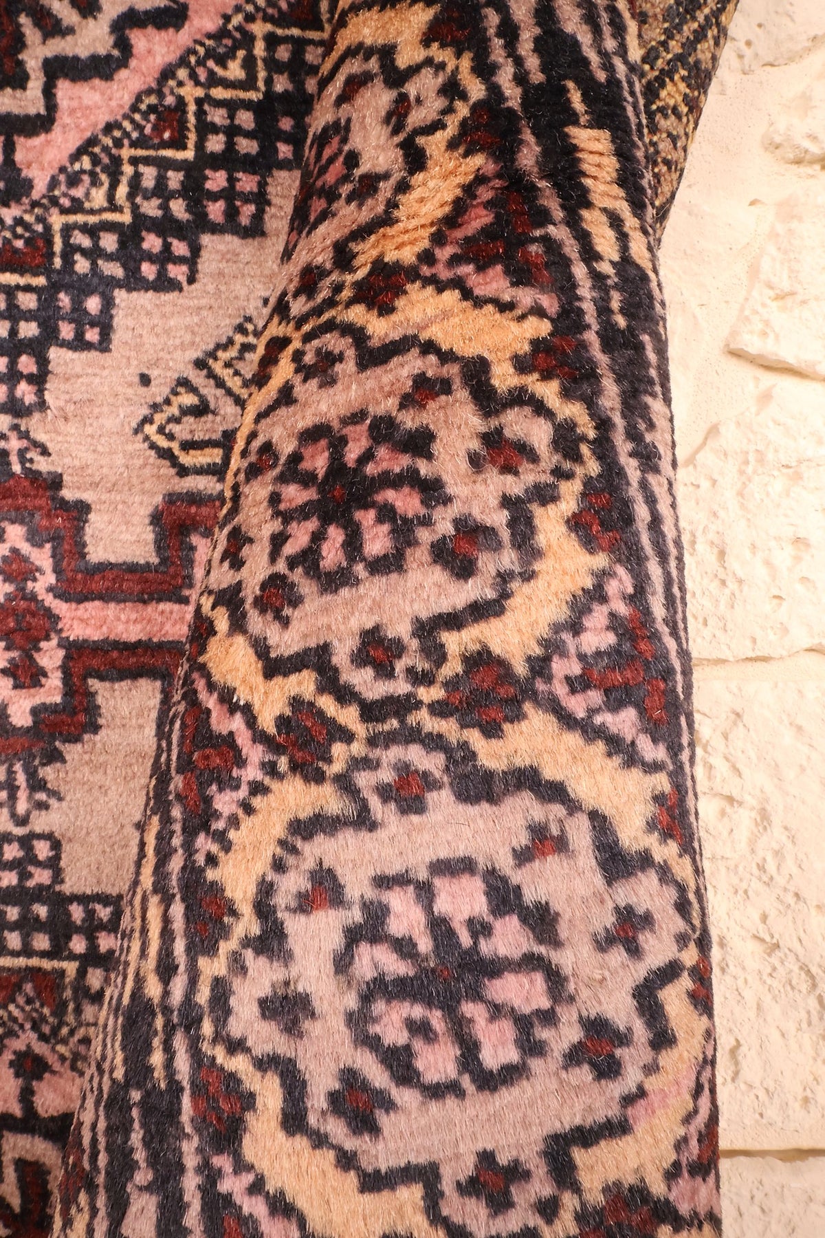 Coin replié du Boukhara rose, rosettes de la bordure vues de près