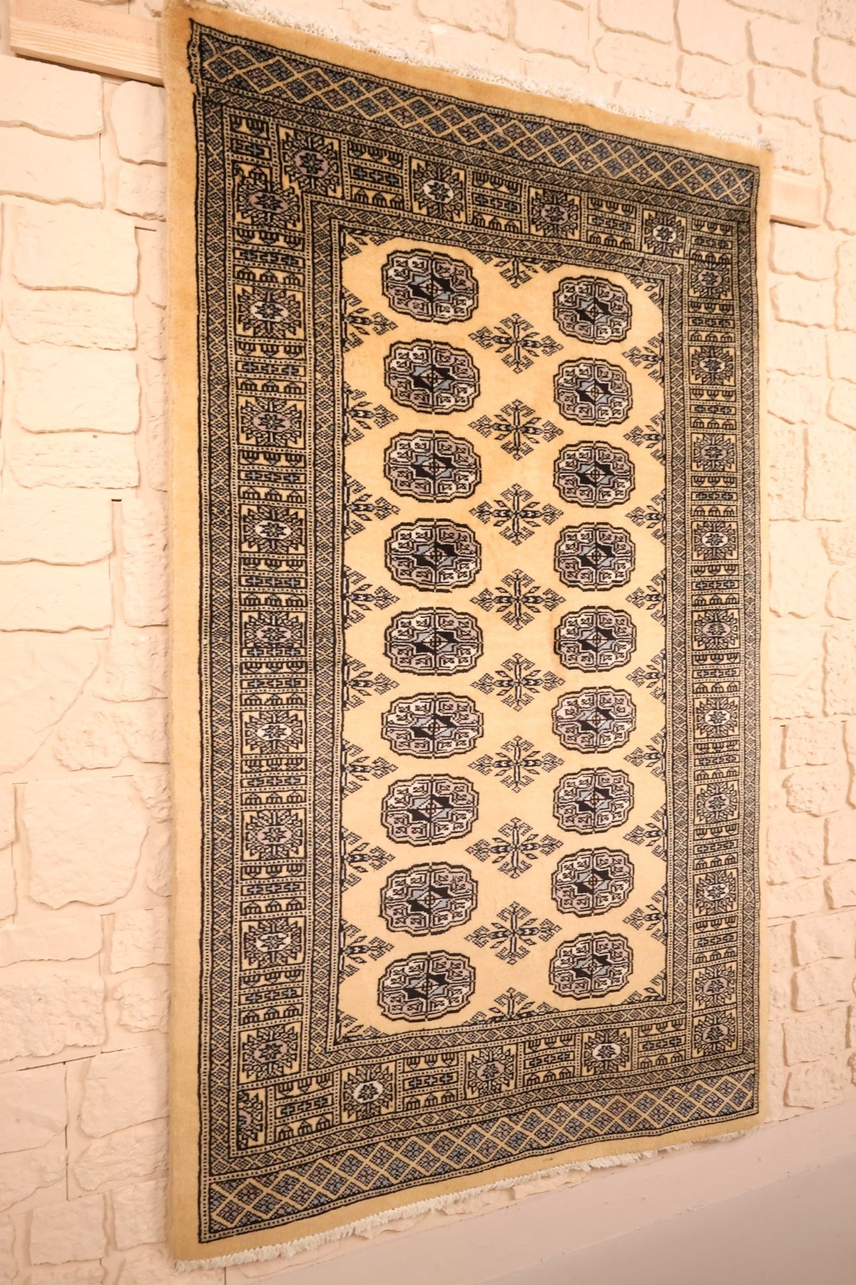 Tapis Boukhara en laine noué à la main, vue de biais sur le champ beige