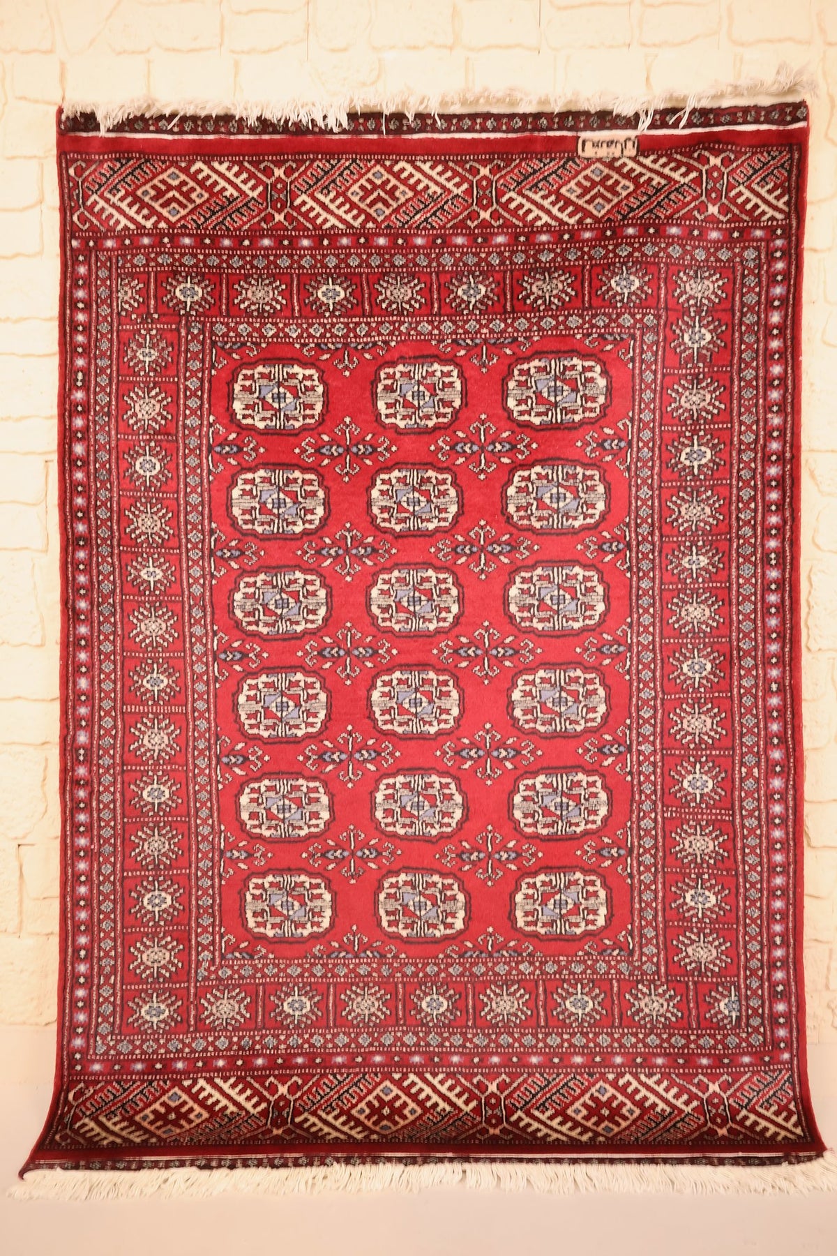 Tapis Boukhara rouge 180 × 126 cm, vue d'ensemble avec ses rangées de guls ivoire