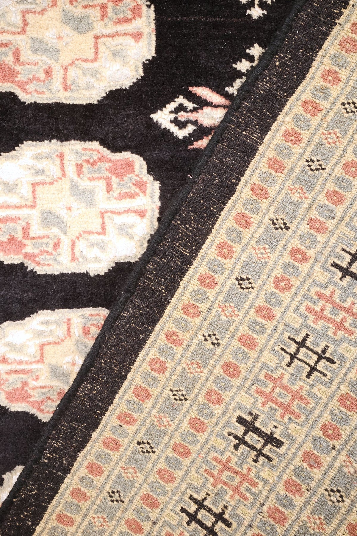 Coin replié du tapis Boukhara noué à la main, envers et bordure visibles