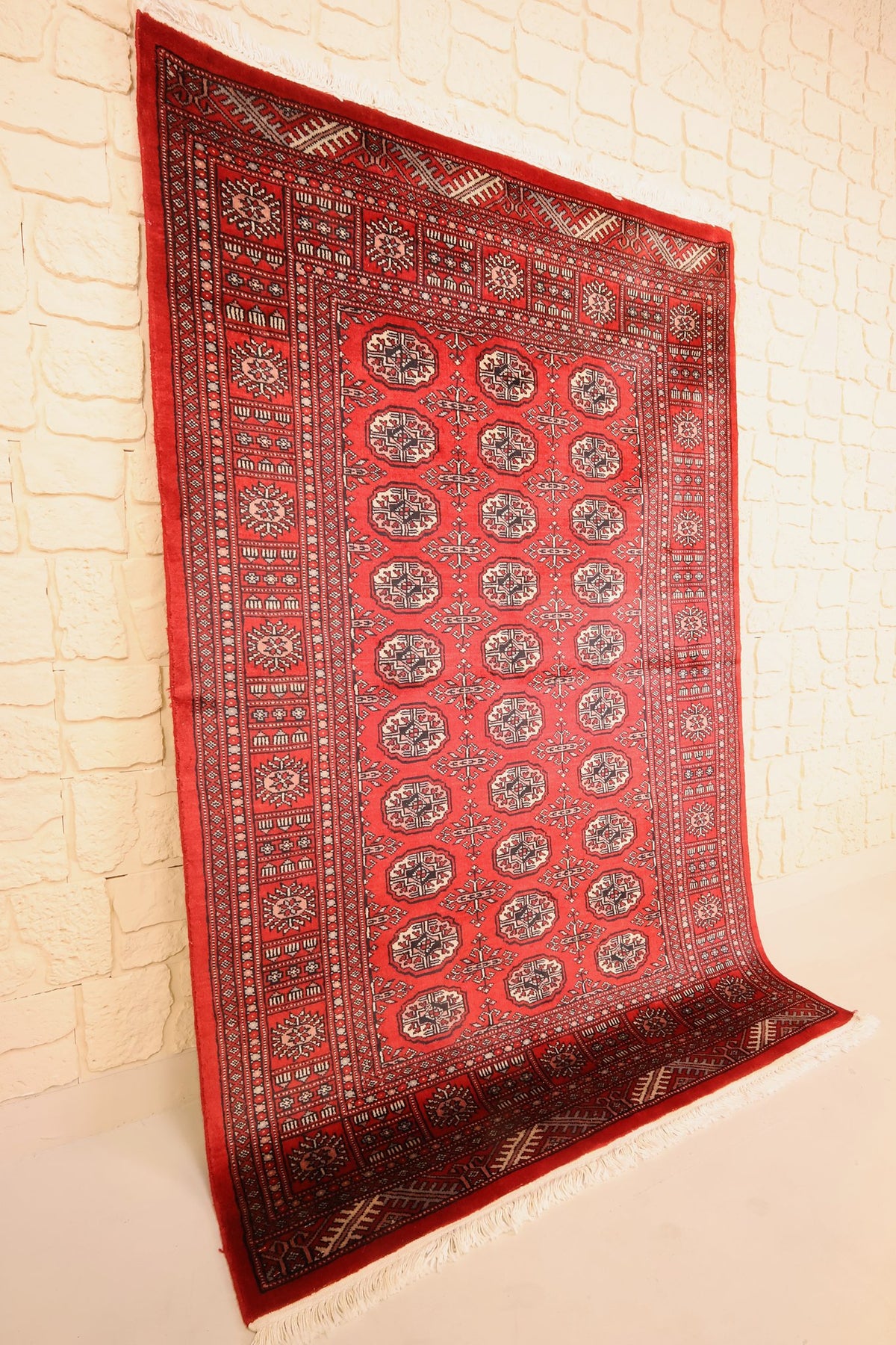 Tapis Boukhara en laine noué à la main, vue de biais du champ rouge rectangulaire