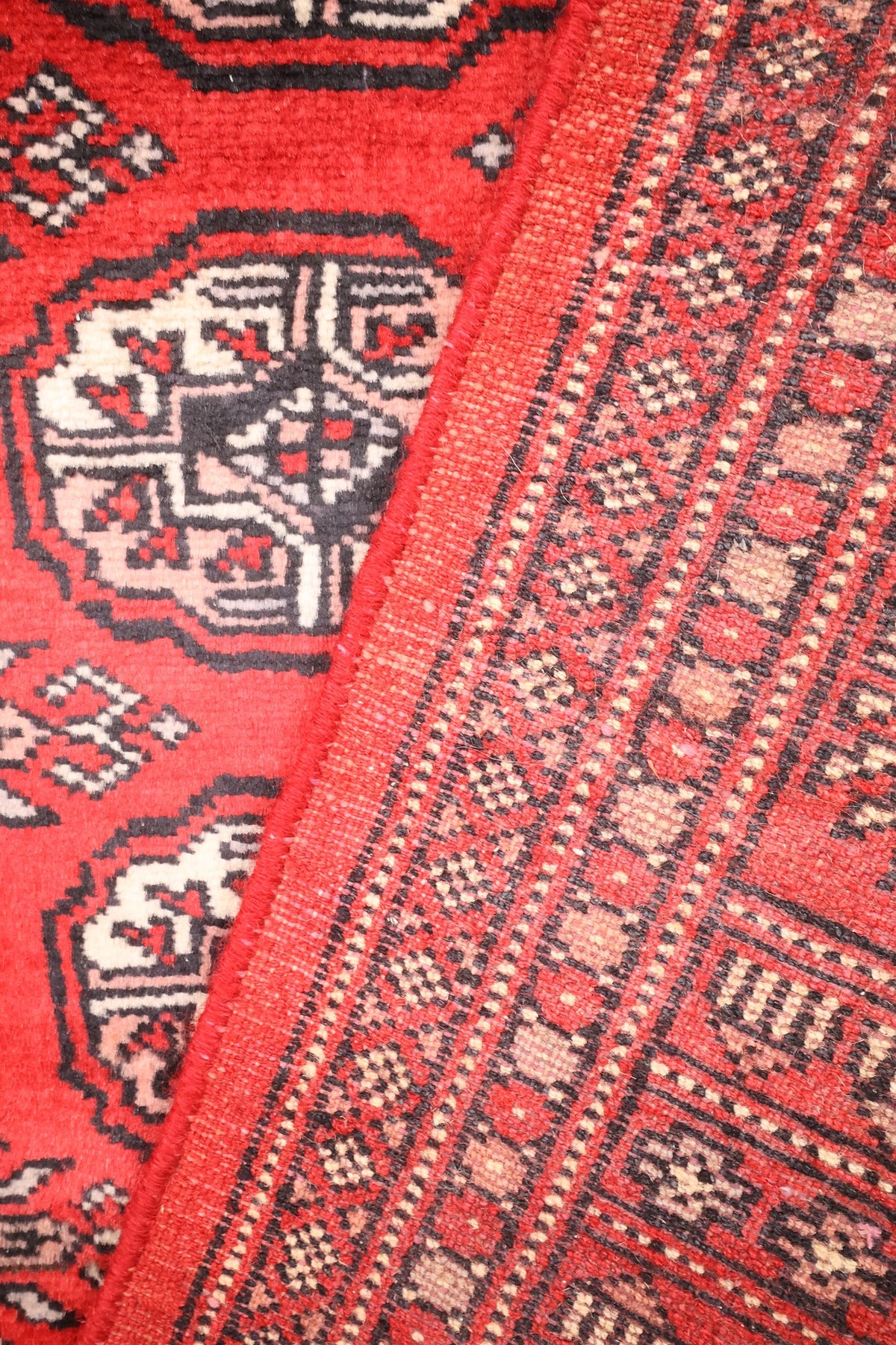 Tapis Boukhara 191 × 126 cm, passage du champ rouge aux bordures secondaires