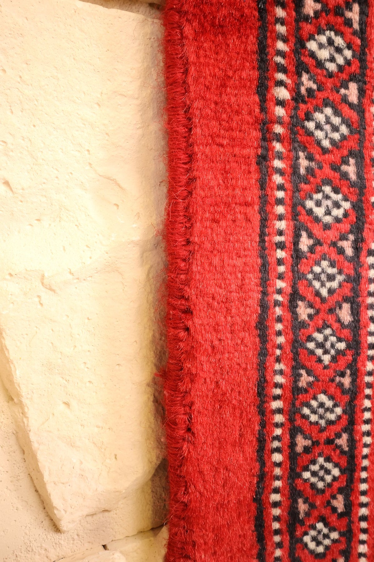 Lisière du tapis Boukhara rouge et frise de losanges beige en bordure