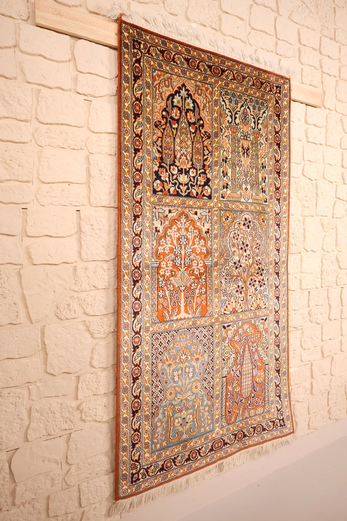 Tapis Cachemire en soie naturelle suspendu, vue de biais sur les compartiments fleuris