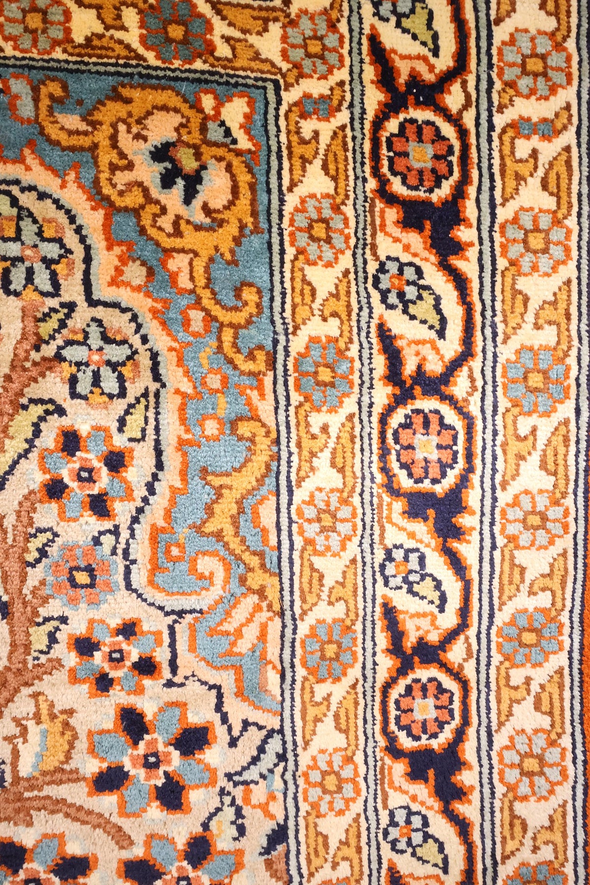 Bordure ivoire à rosettes et palmettes, contre-bordures bleu nuit et orange
