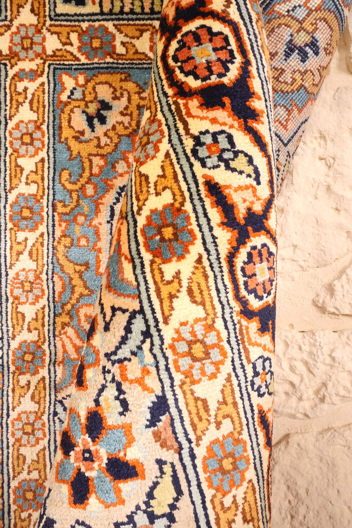Coin replié du tapis Cachemire, épaisseur et dessin floral de la bordure