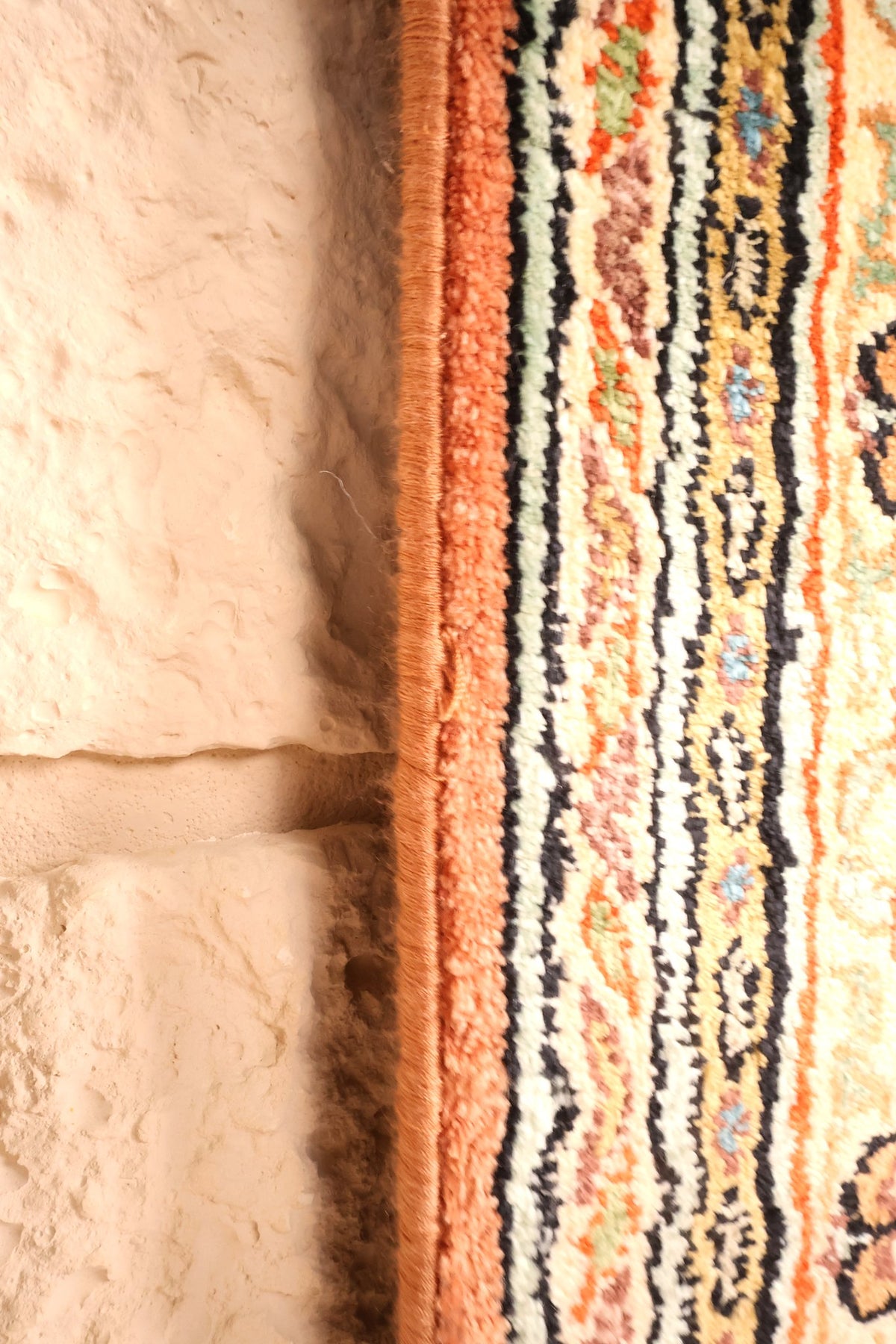 Lisière du tapis Cachemire en soie artificielle, bord rose le long des filets ivoire