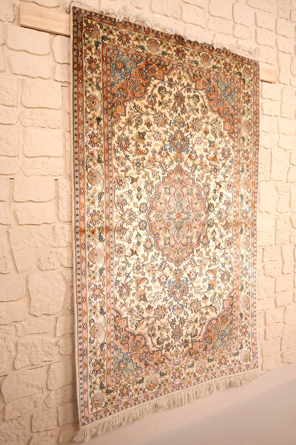 Tapis Cachemire beige et orange vu de biais, médaillon lobé et franges claires