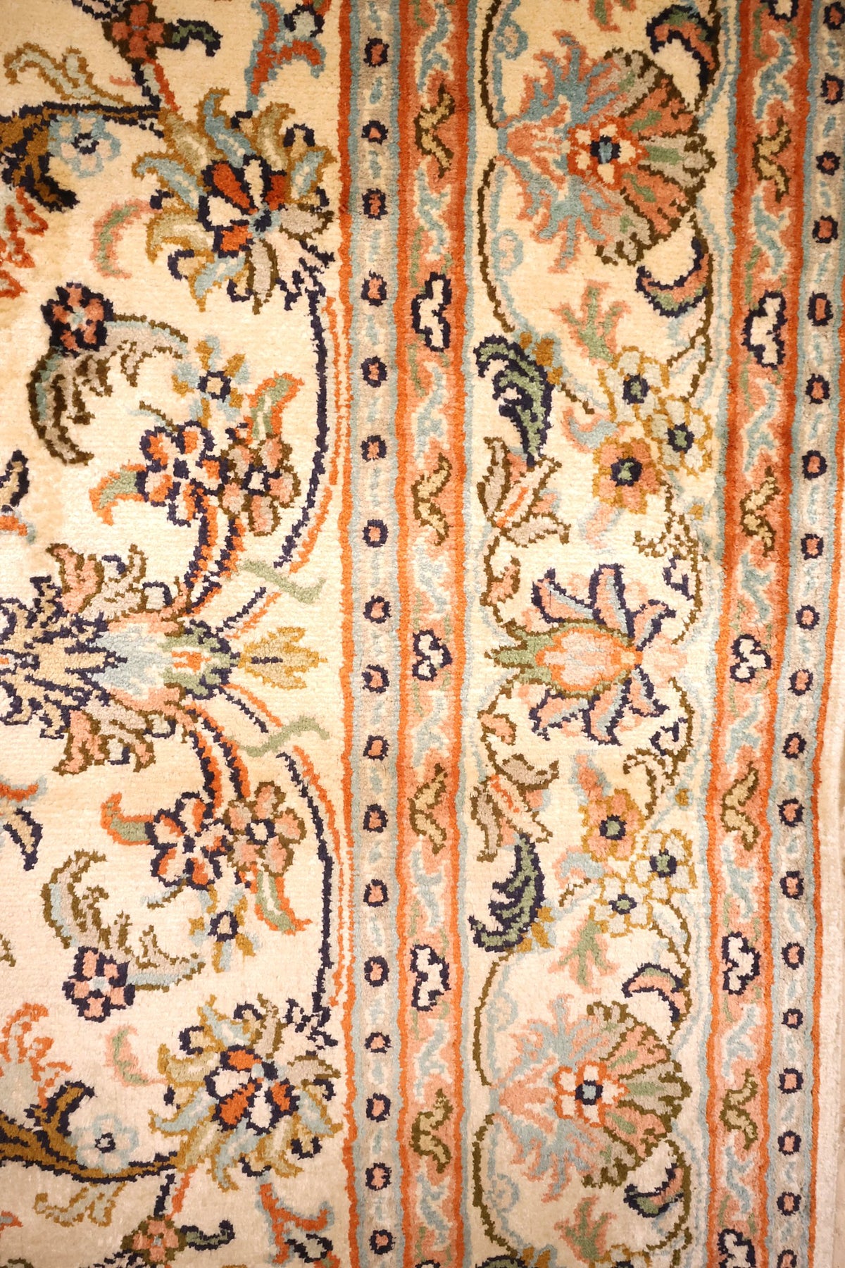 Bordure ivoire fleurie et contre-bordures à filets orange du tapis Cachemire
