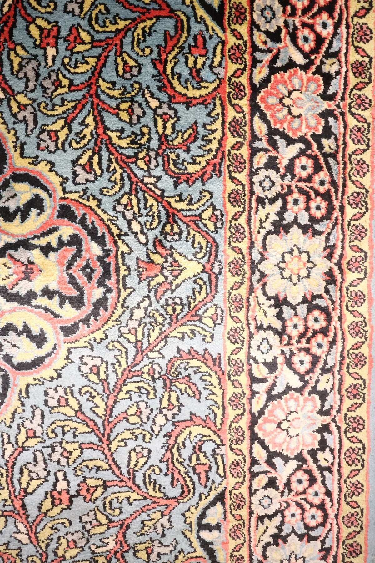 Bordure noire à rosettes roses et contre-bordure jaune du tapis Cachemire