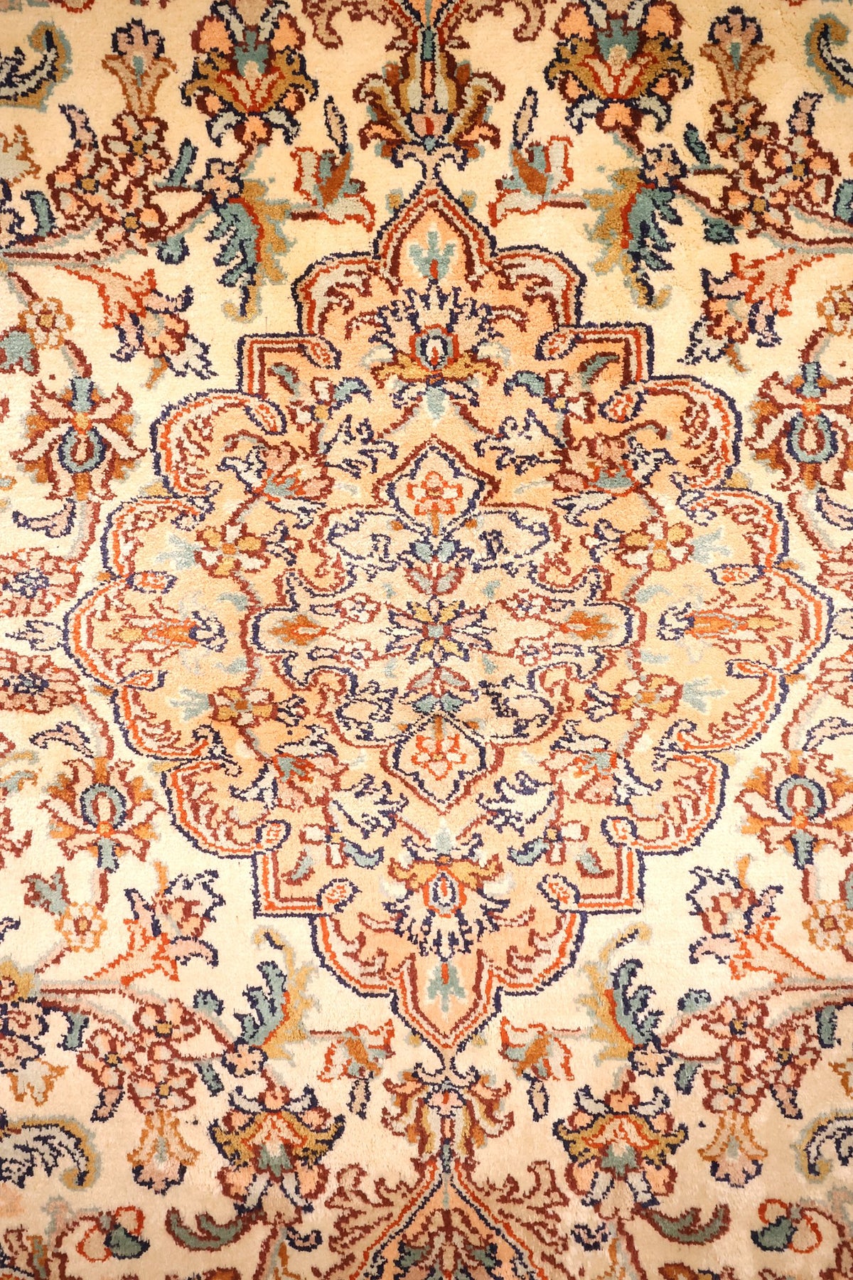 Détail du médaillon lobé rose saumon à contour bleu nuit, tapis Cachemire