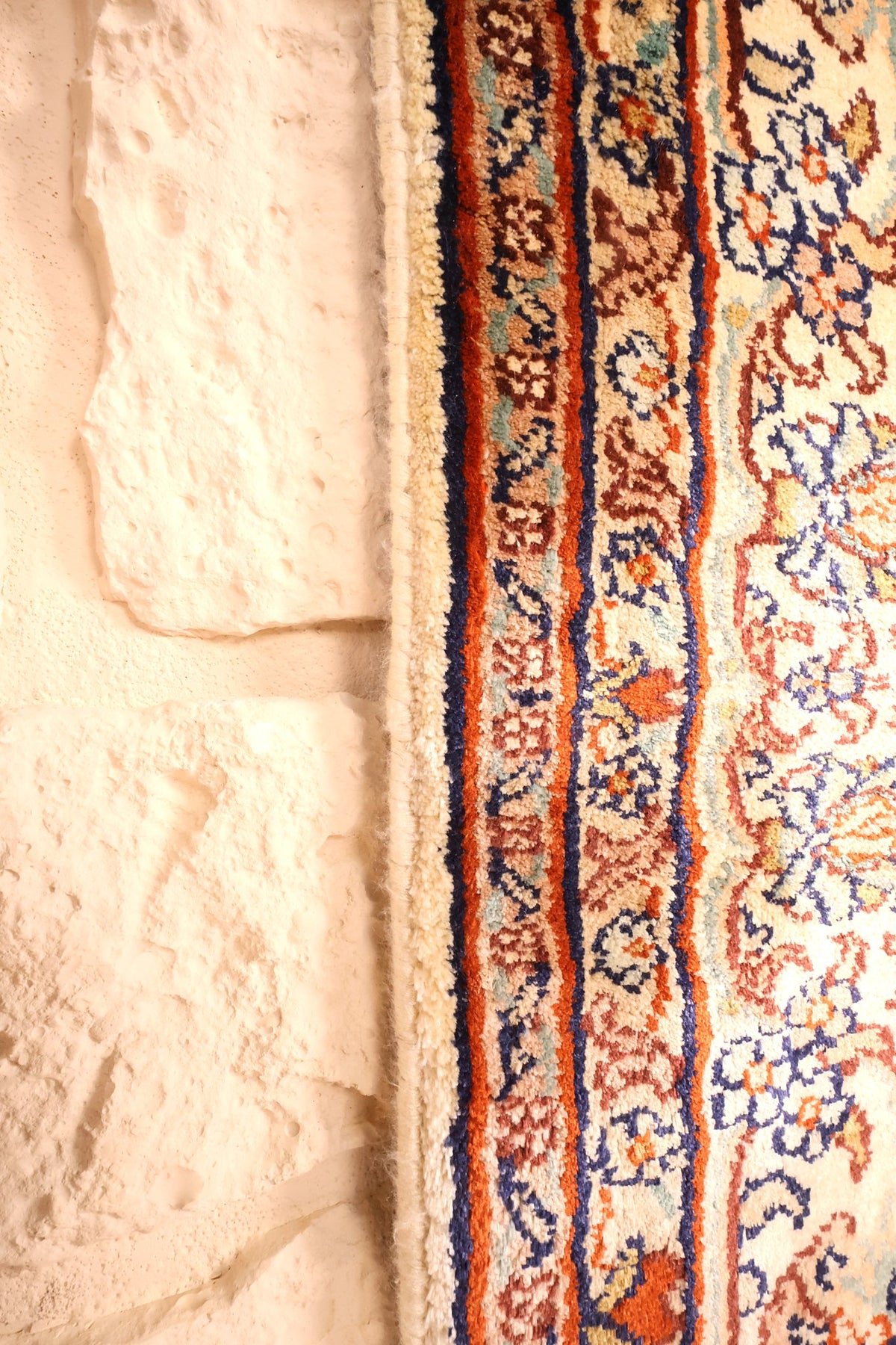 Lisière et franges du tapis Cachemire, liserés orange et bleu en gros plan