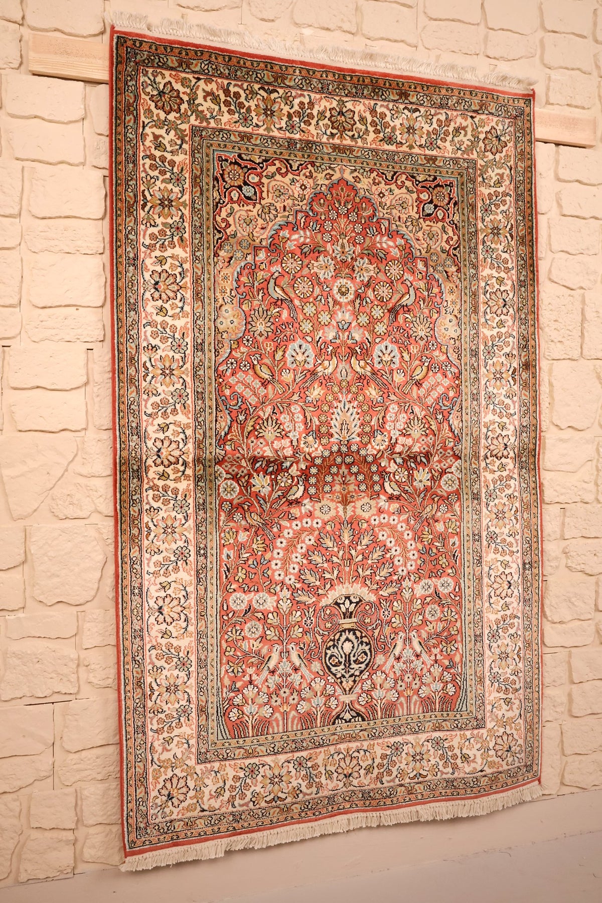 Tapis Cachemire en soie nouée main, vue de biais montrant le vase fleuri et les franges