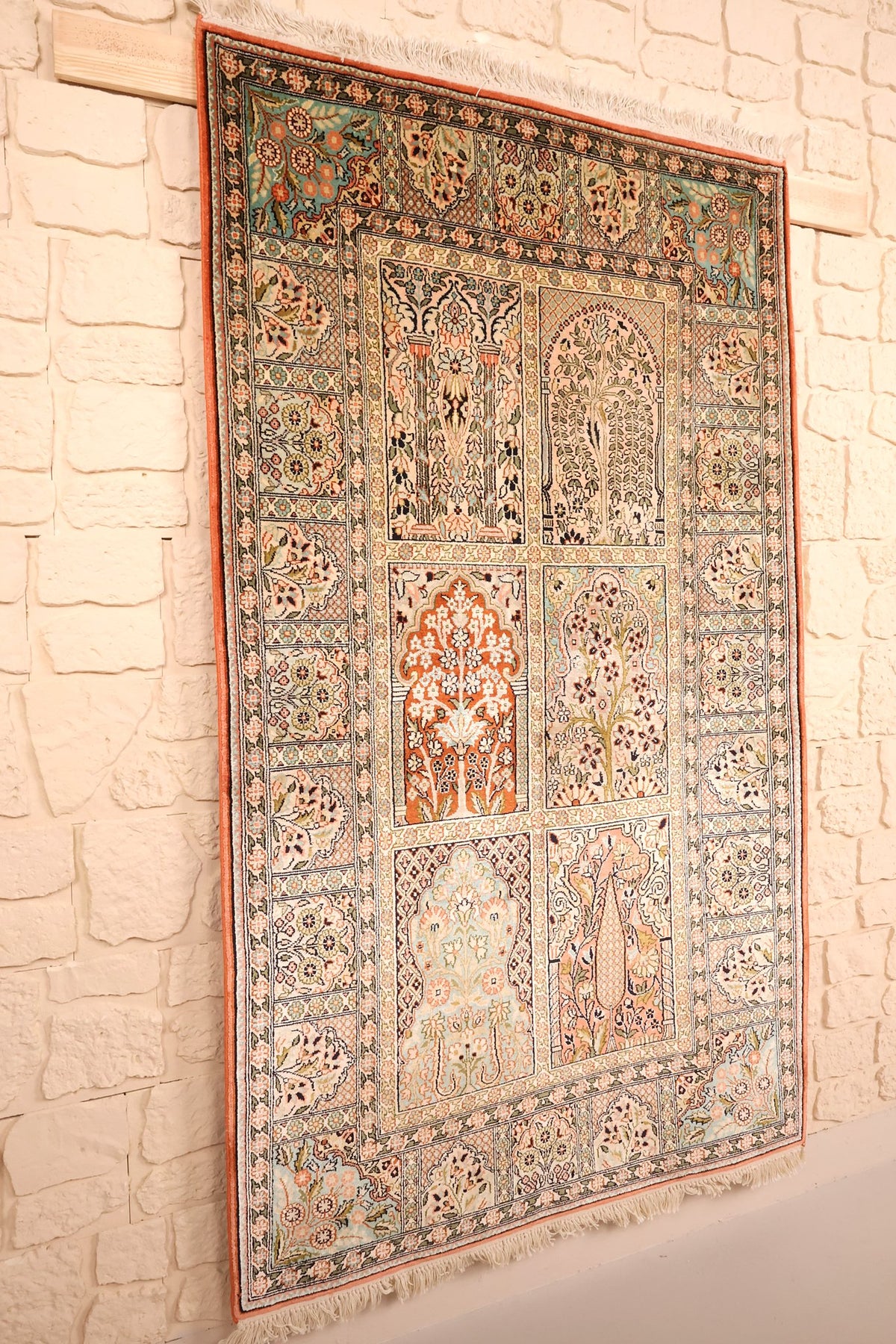 Tapis Cachemire beige et orange vu de biais, compartiments fleuris et franges claires