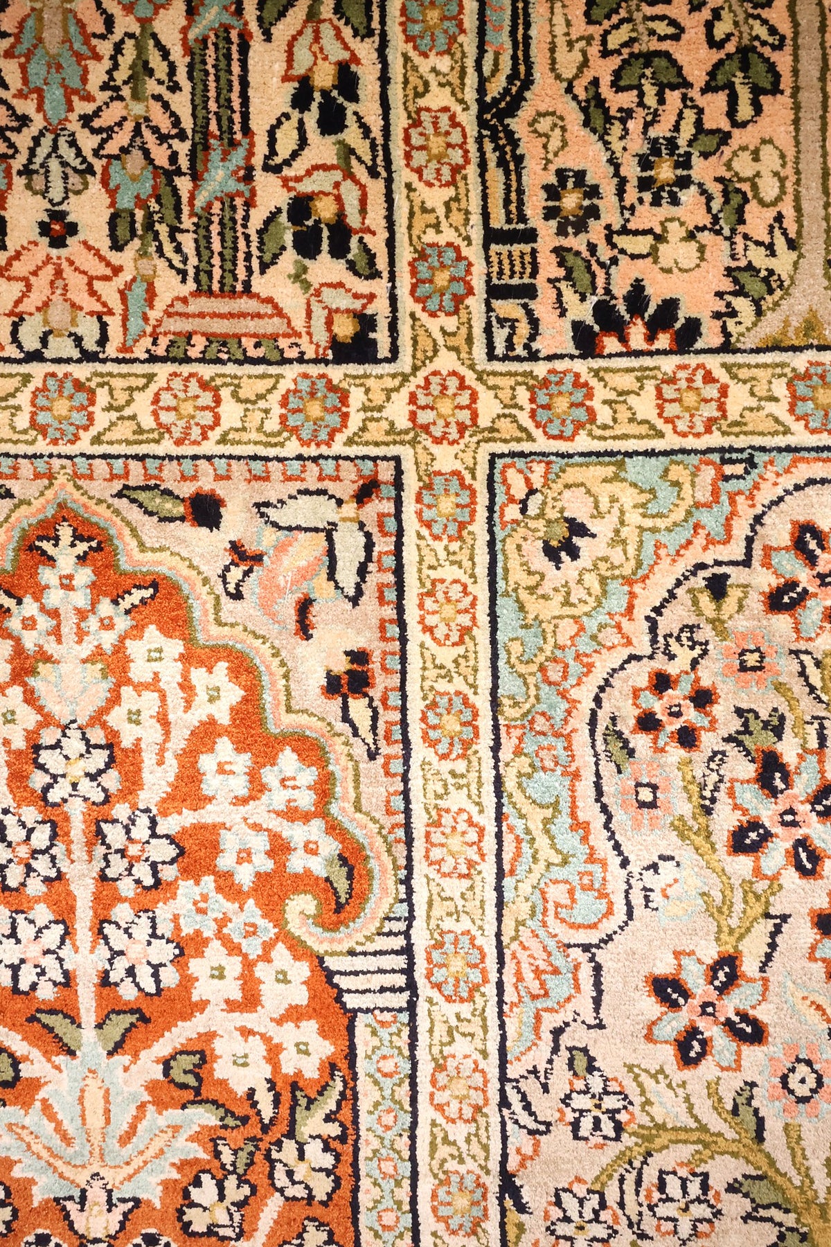 Détail des arcades fleuries beige, orange brique et vert d'eau du tapis Cachemire
