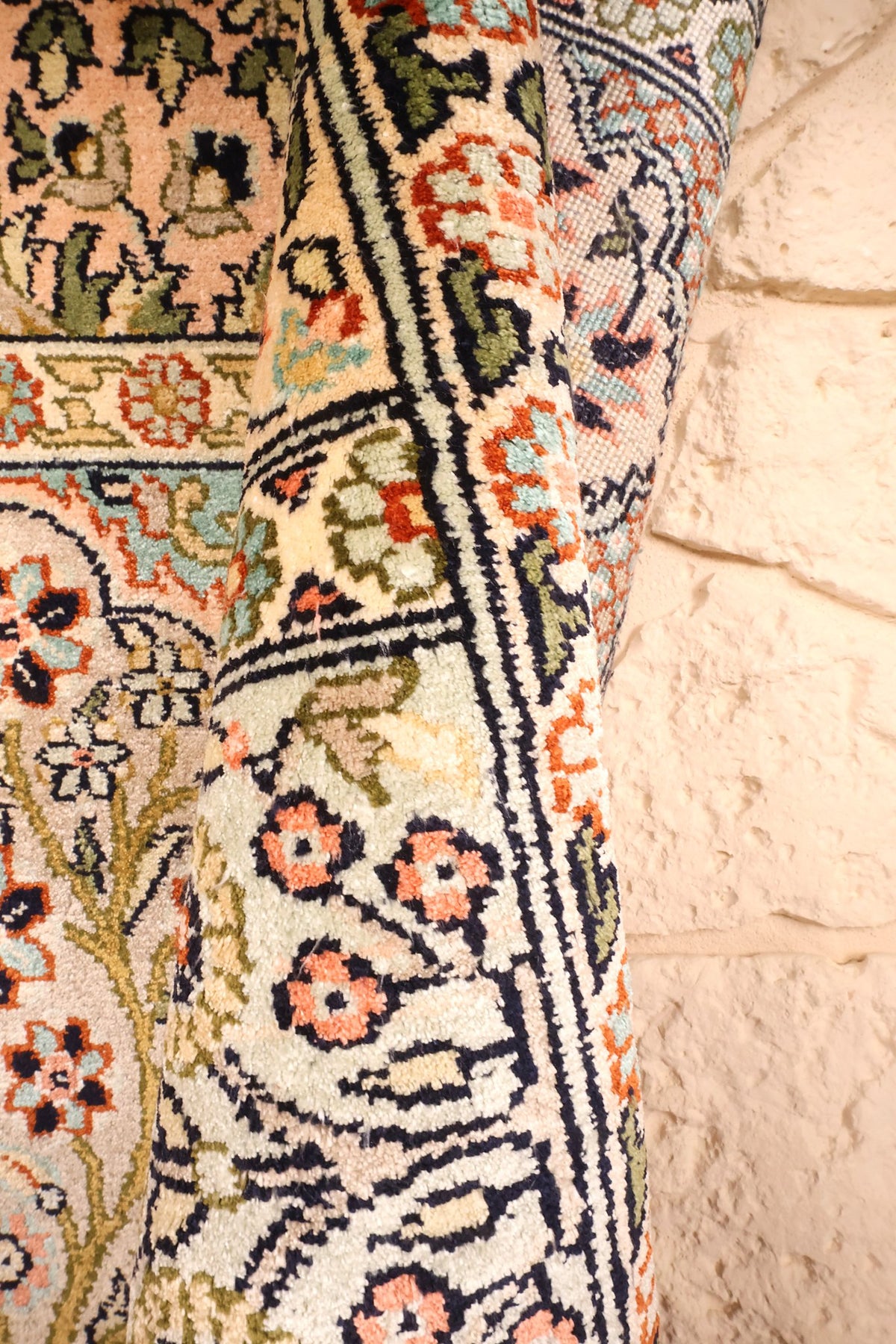 Lisière du tapis Cachemire beige, bandes florales repliées sur le mur