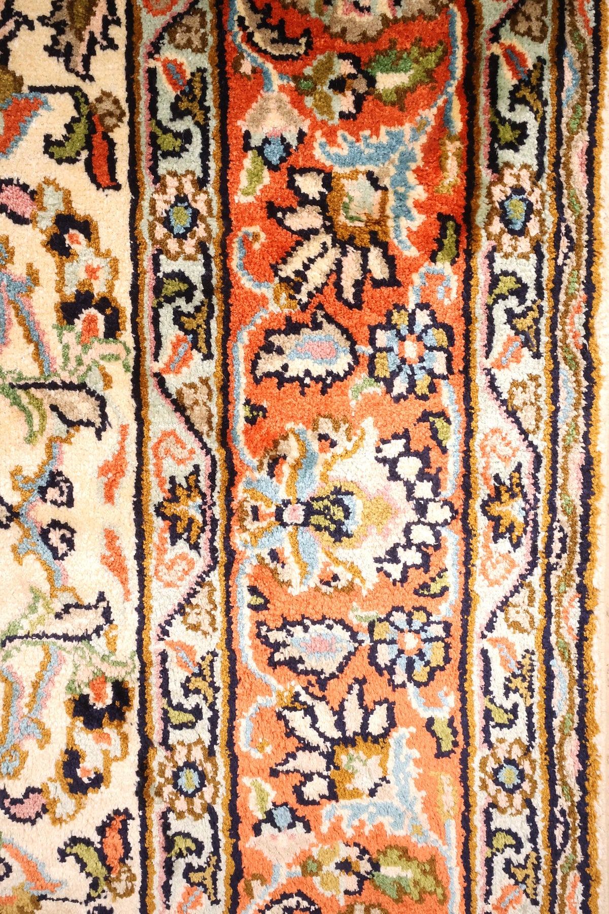 Bordure orange à palmettes et filets bleu nuit du tapis Cachemire beige