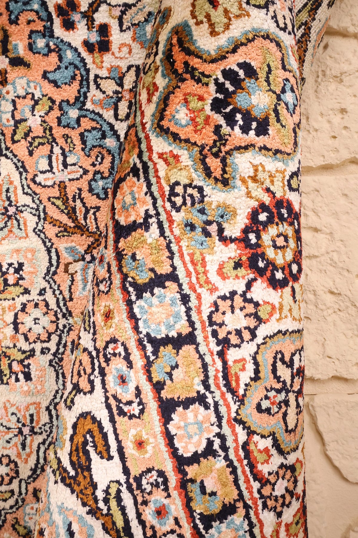 Tapis Cachemire orange et bleu vu de biais, rinceaux fleuris et bordure
