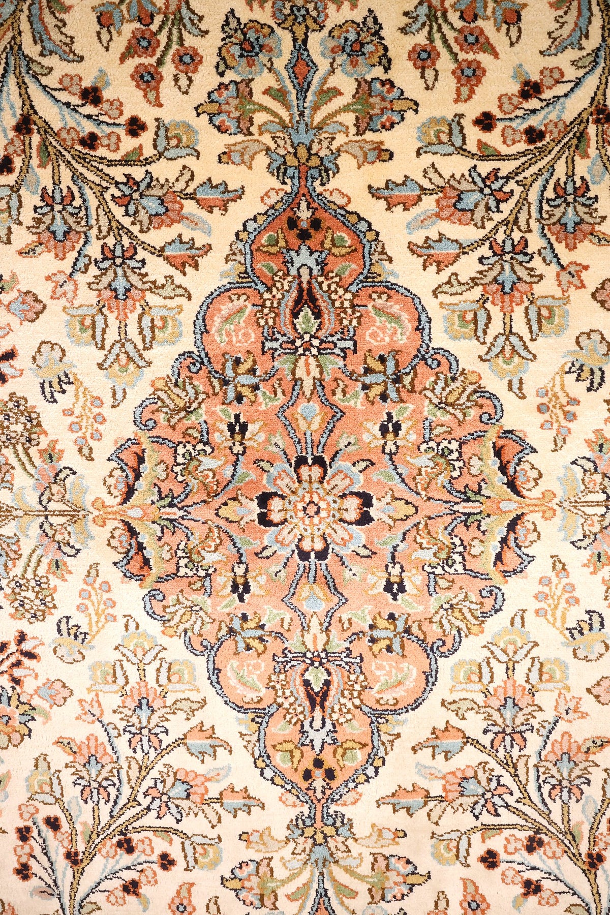 Détail du médaillon losangé orange saumon et des bouquets du tapis Cachemire
