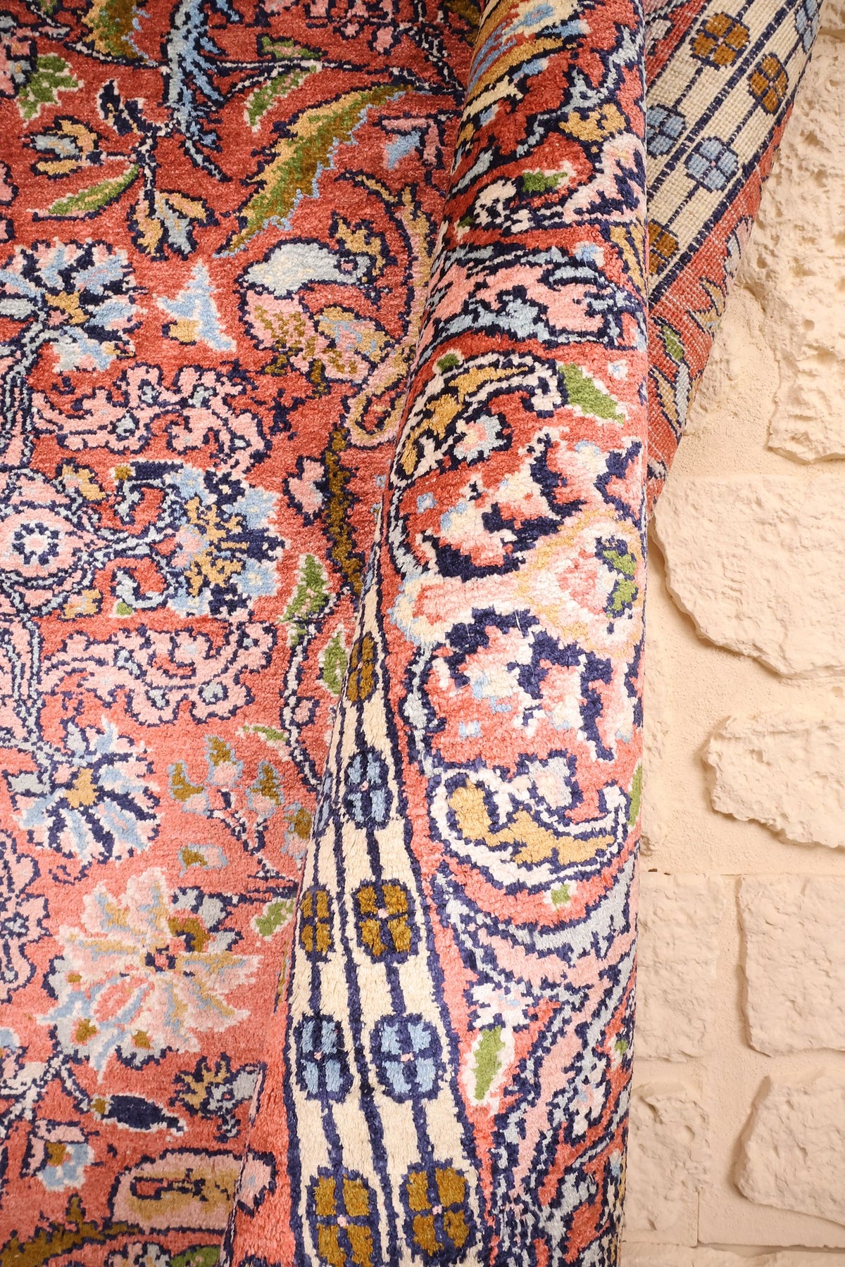 Coin replié du tapis Cachemire, envers et nœuds visibles le long de la bordure