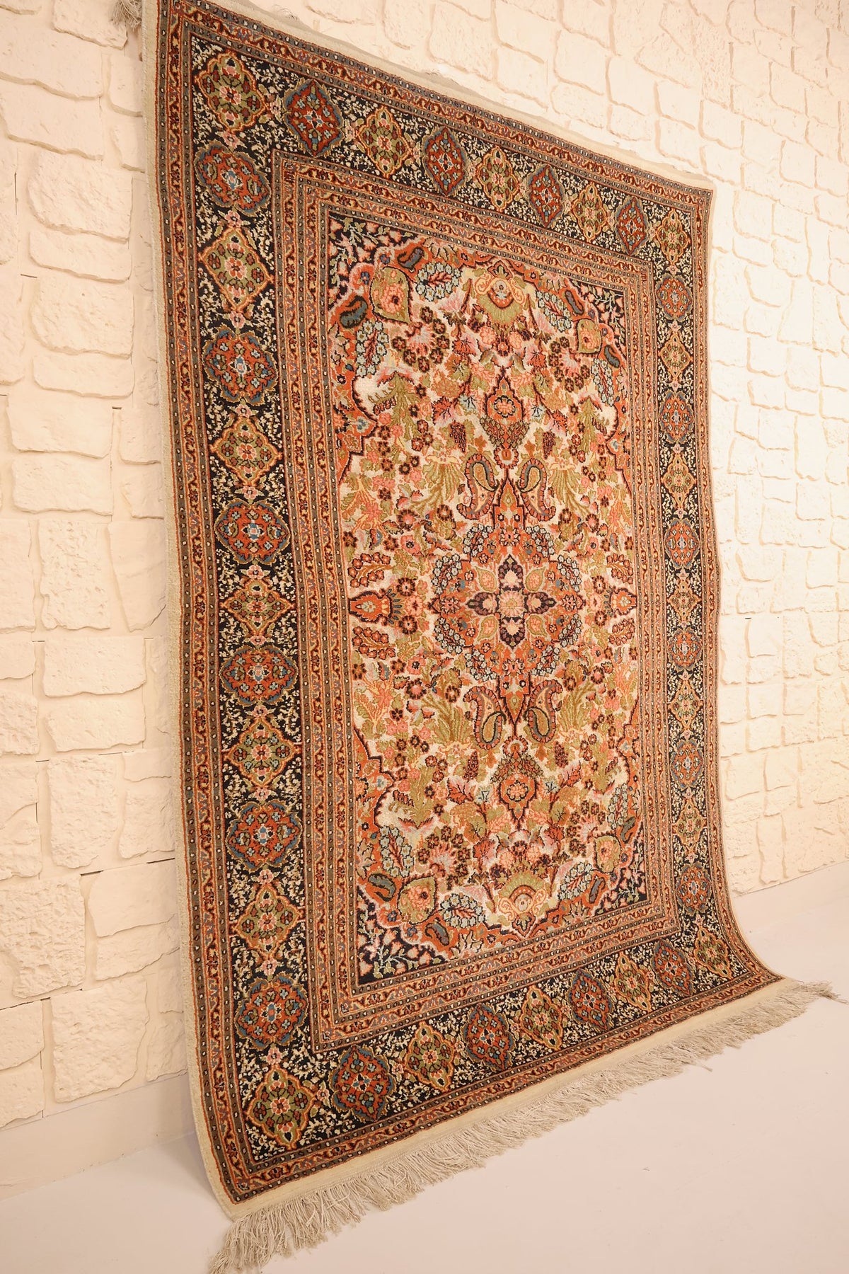 Tapis Cachemire en laine et soie vu de biais, médaillon central et bordure bleu nuit