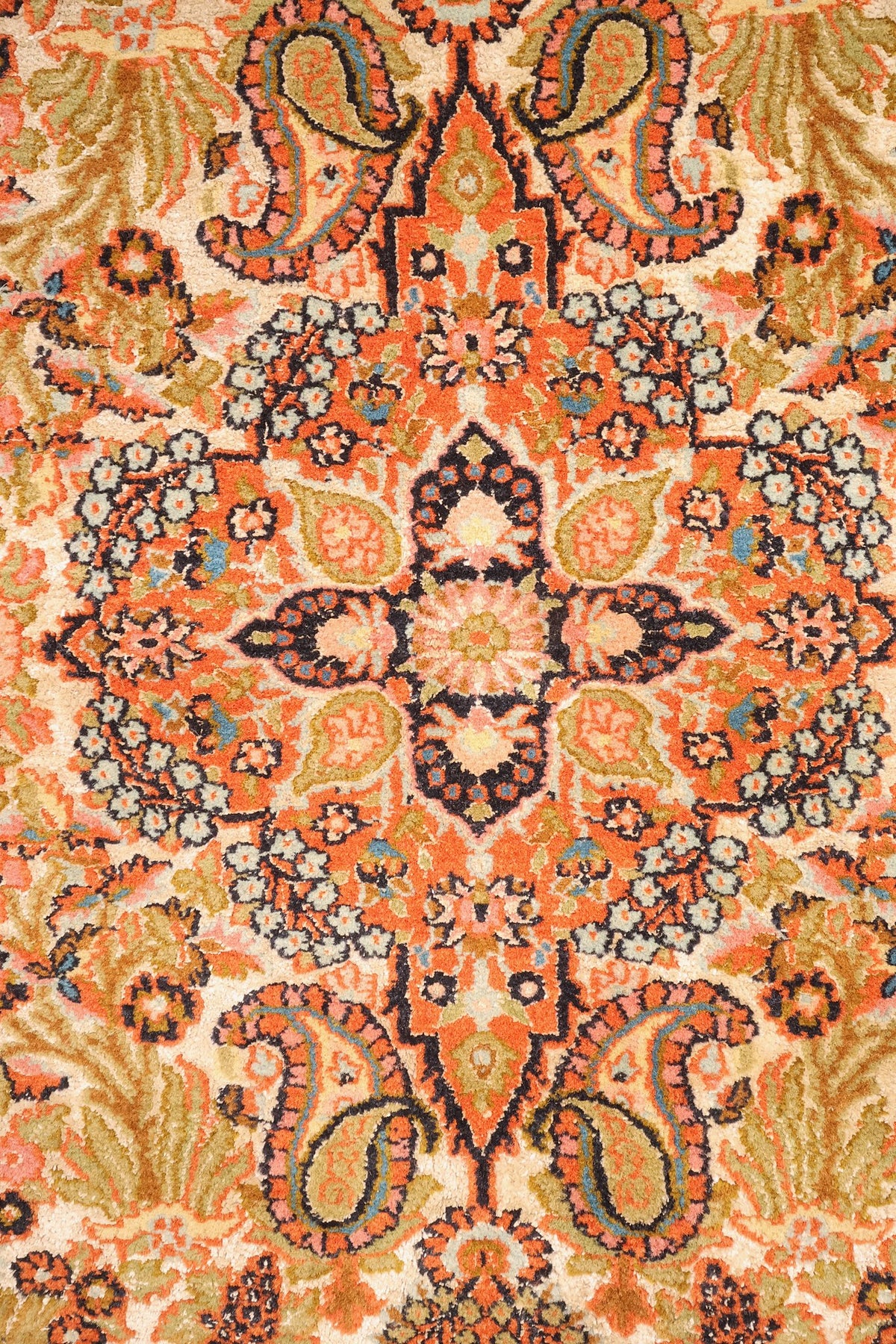 Détail du médaillon étoilé et des boteh orange du tapis Cachemire