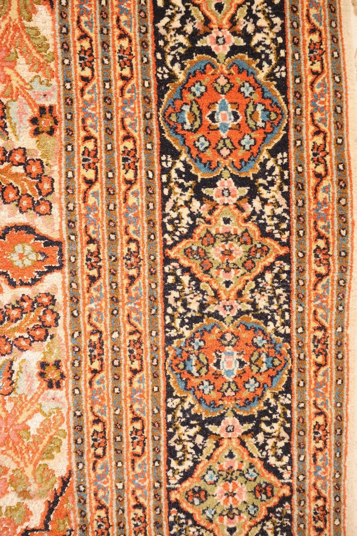 Bordure bleu nuit à cartouches floraux orange et contre-bordures à fleurettes, tapis Cachemire