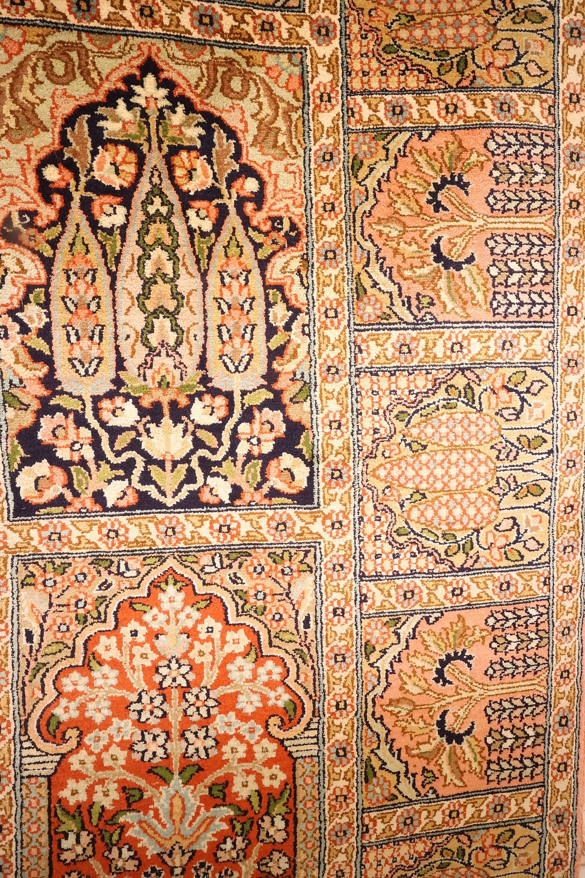 Motifs floraux bleu nuit et orange près de la bordure à panneaux du tapis Cachemire