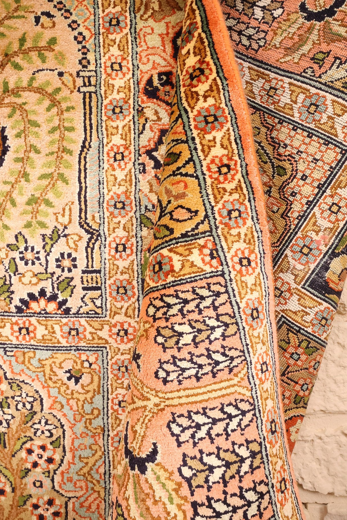 Lisière et bordure saumon du tapis Cachemire beige, coin retourné sur le champ