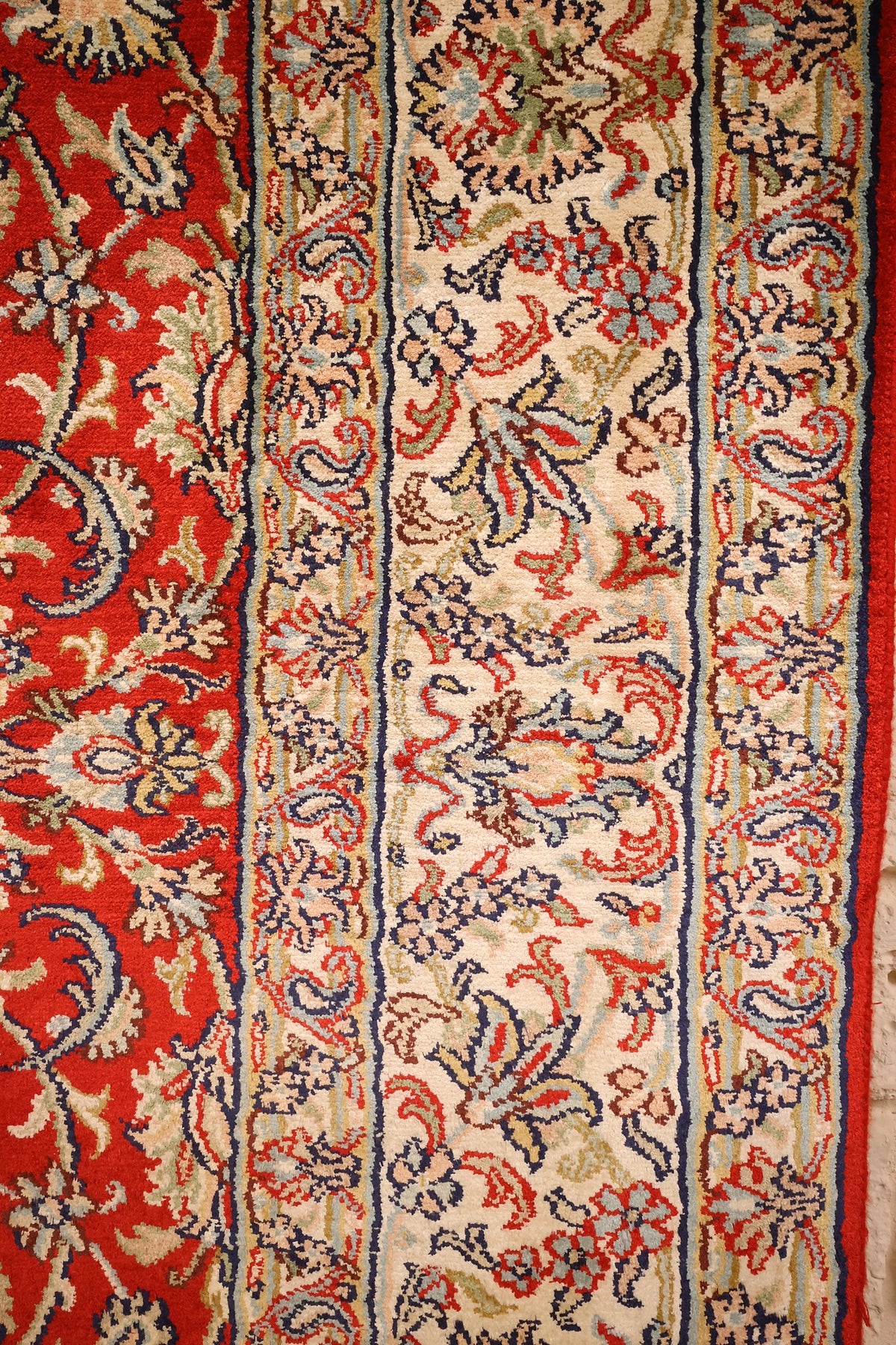 Bordure ivoire fleurie du tapis Cachemire, contre-bordures bleu foncé et jaune