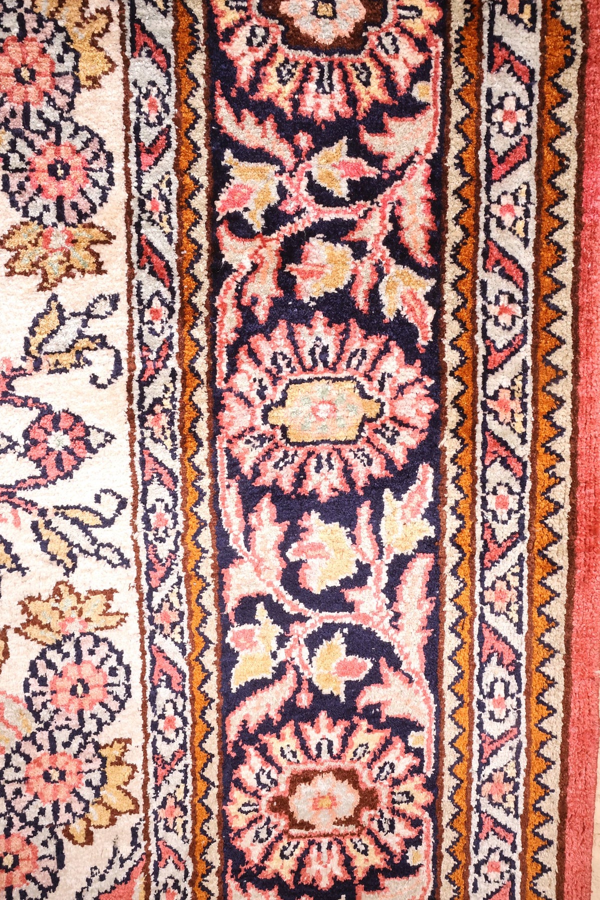 Bordure bleu nuit à palmettes du tapis Cachemire, contre-bordures ivoire et orange