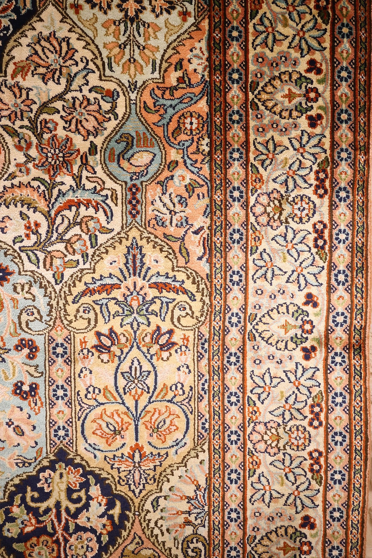 Bordure claire à semis de fleurs et boteh du tapis Cachemire, galons orange et bleus