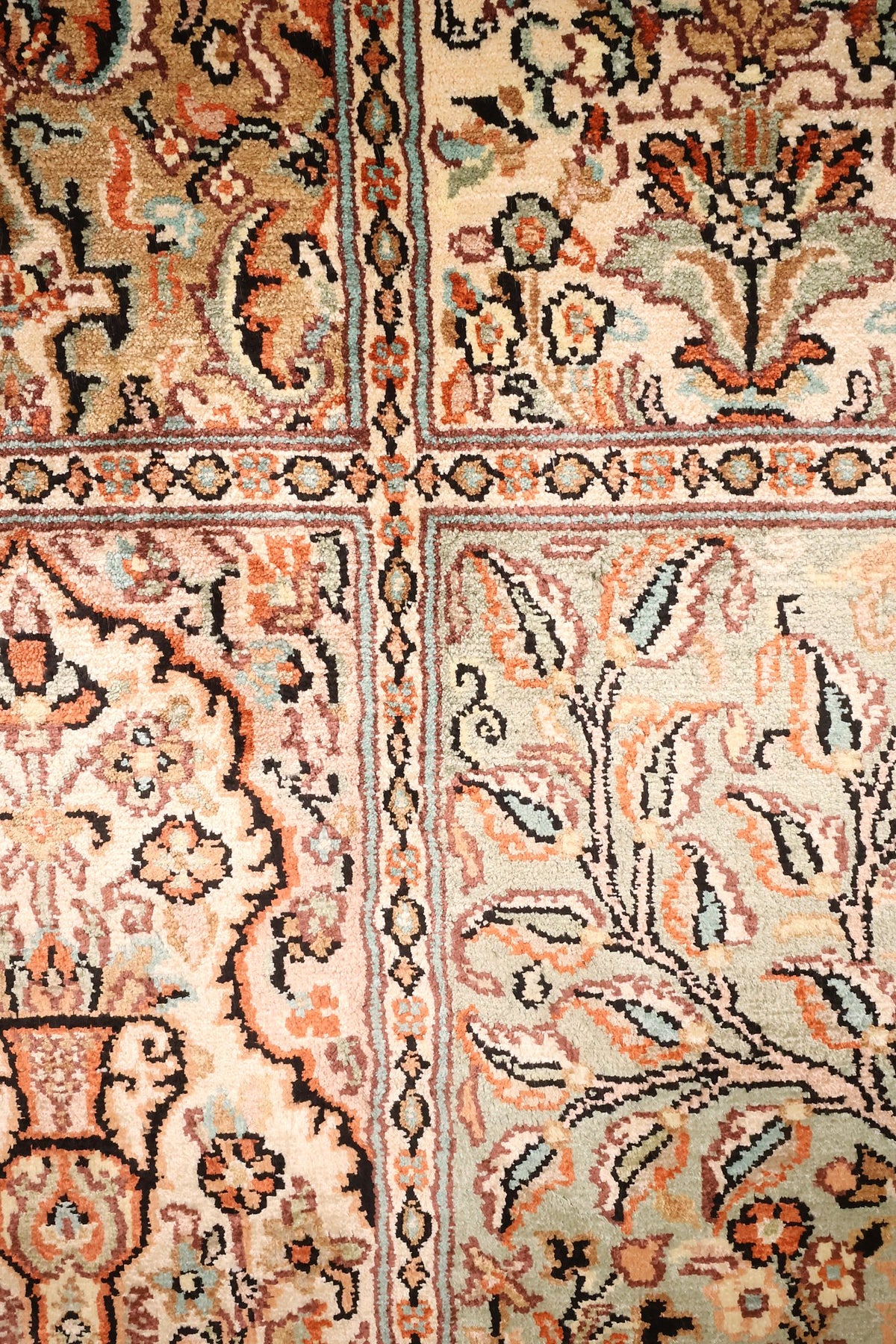 Détail des compartiments du tapis Cachemire : vases fleuris et bouquets orangés