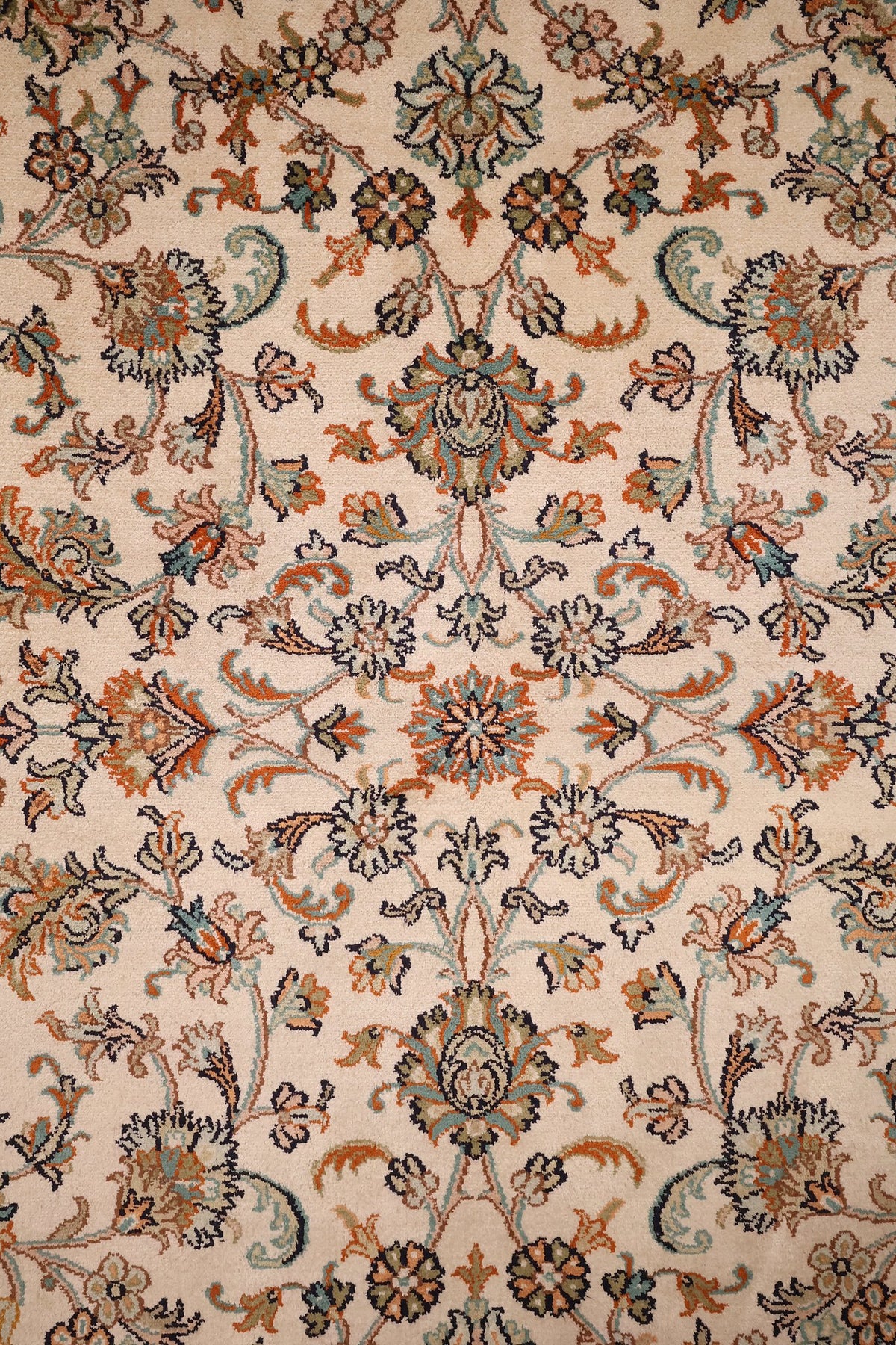 Détail du champ ivoire du tapis Cachemire, palmettes orange, bleu-vert et rose