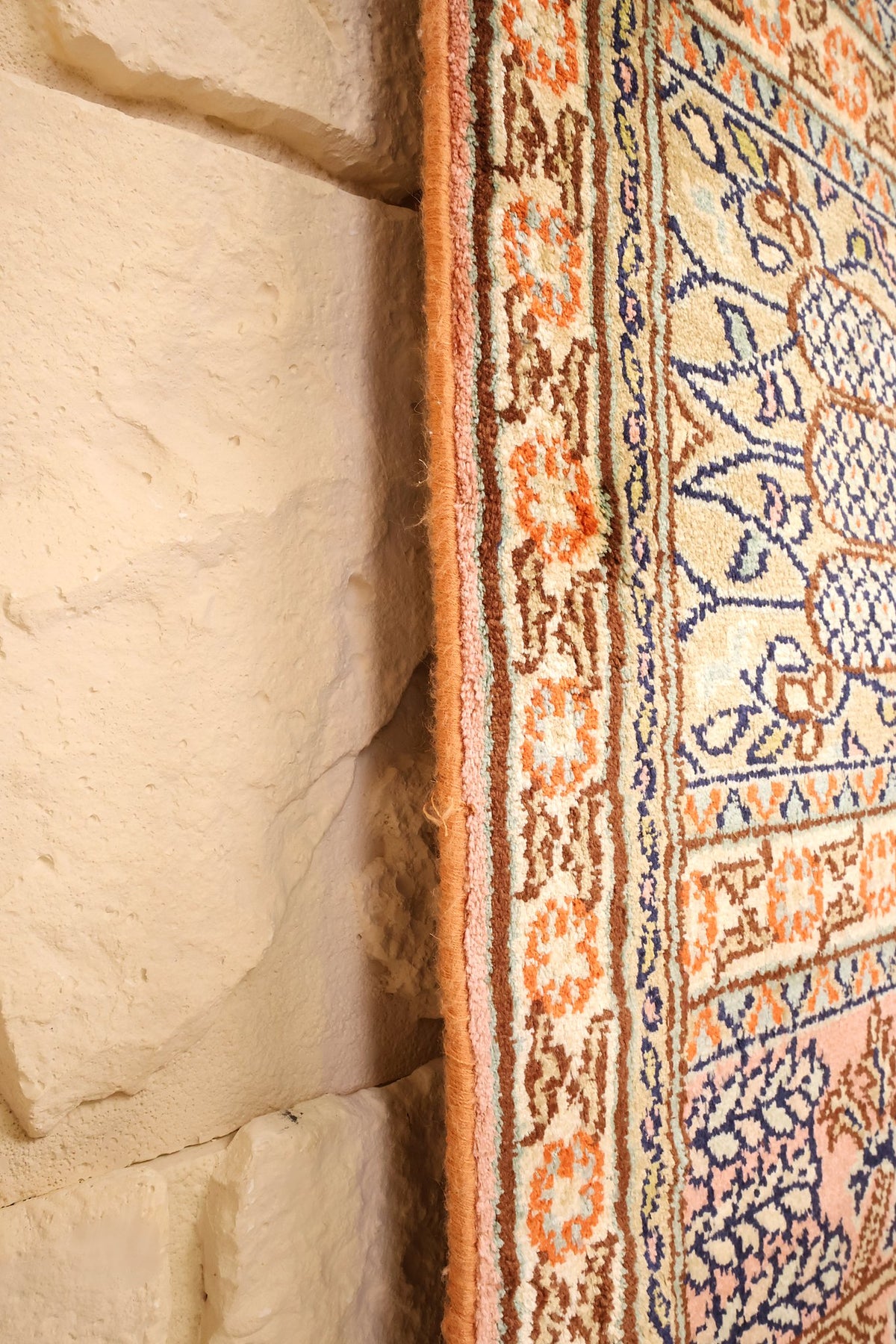Lisière du tapis Cachemire en soie beige, bordure orange et brune de près